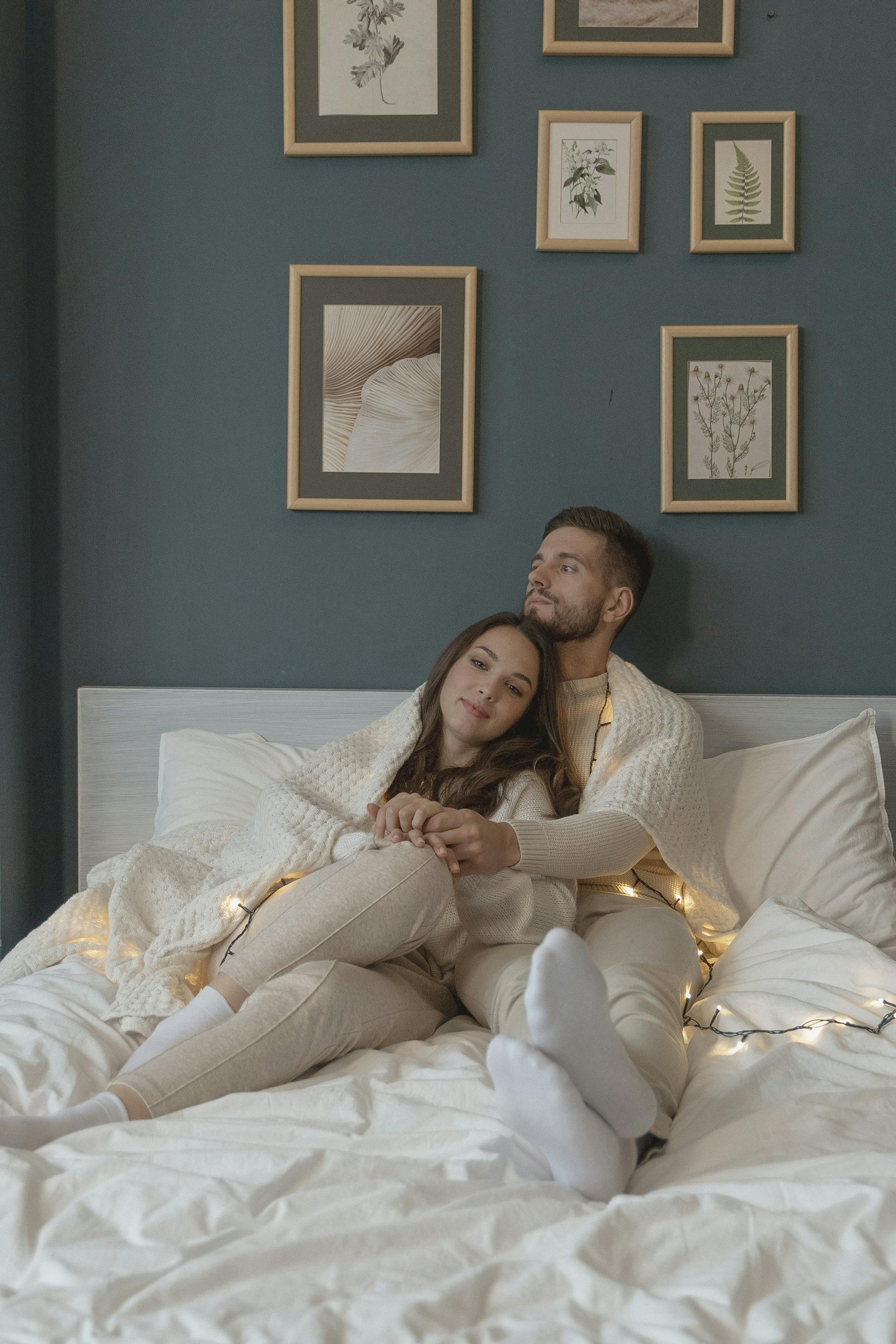 Un couple assis ensemble dans un lit | Source : Pexels
