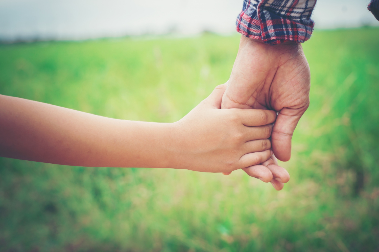 Un enfant tenant la main de son père | Source : Freepik