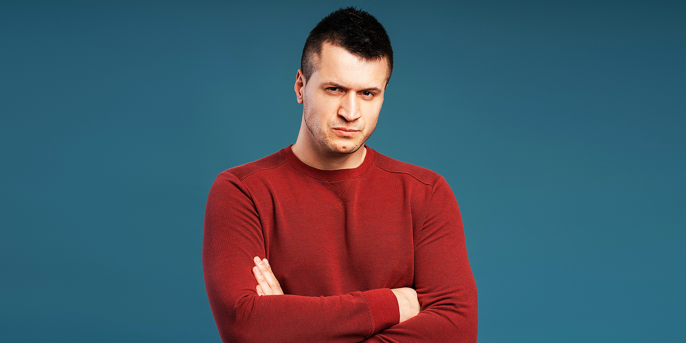 Un homme debout avec les bras croisés | Source : Shutterstock