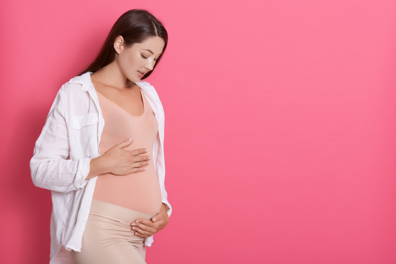 Une femme enceinte qui regarde son baby bump | Source : Freepik