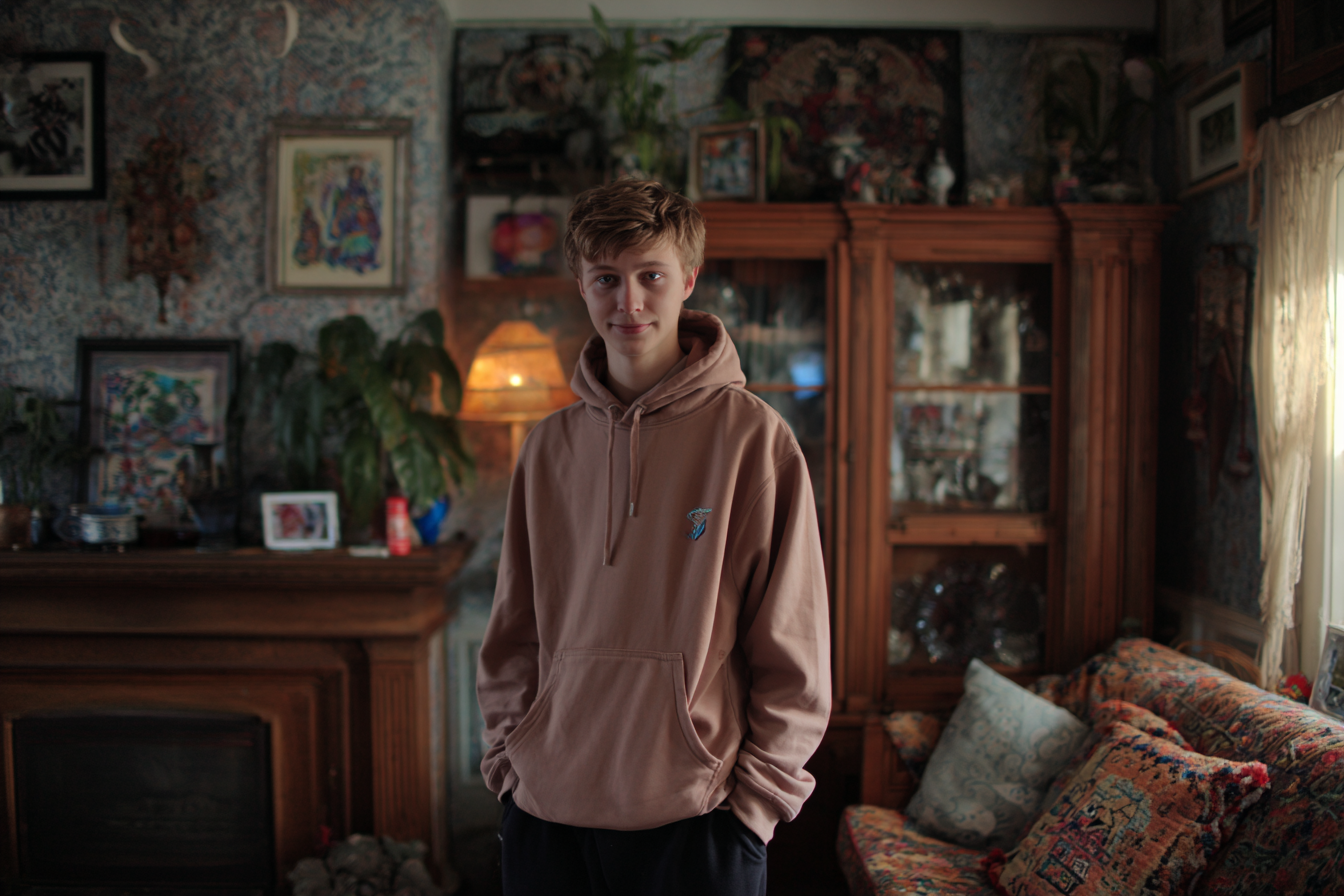 Un adolescent debout dans un salon | Source : Midjourney