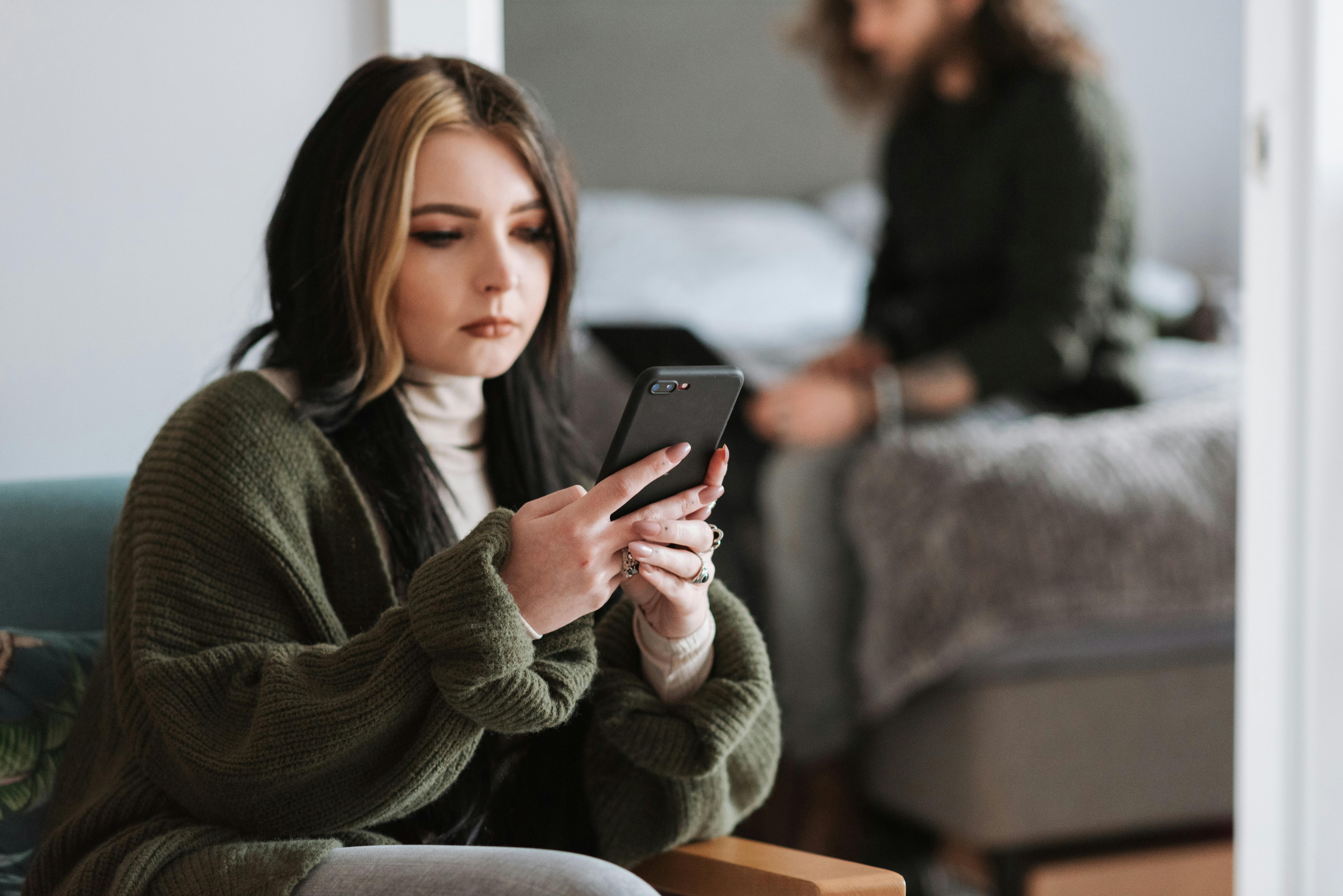 Une femme qui fait défiler son téléphone | Source : Pexels