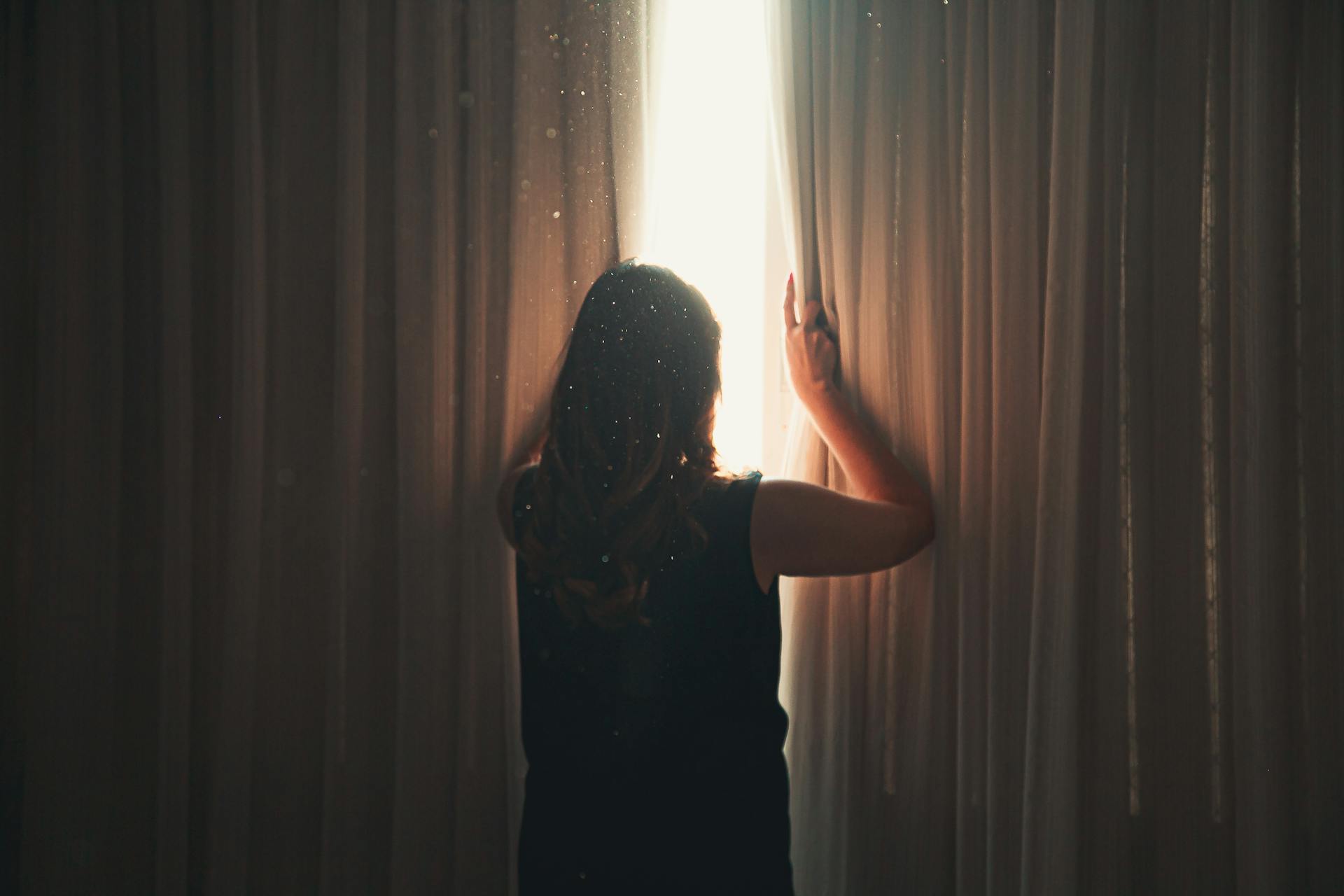 Une femme qui regarde à l'extérieur d'une fenêtre | Source : Pexels