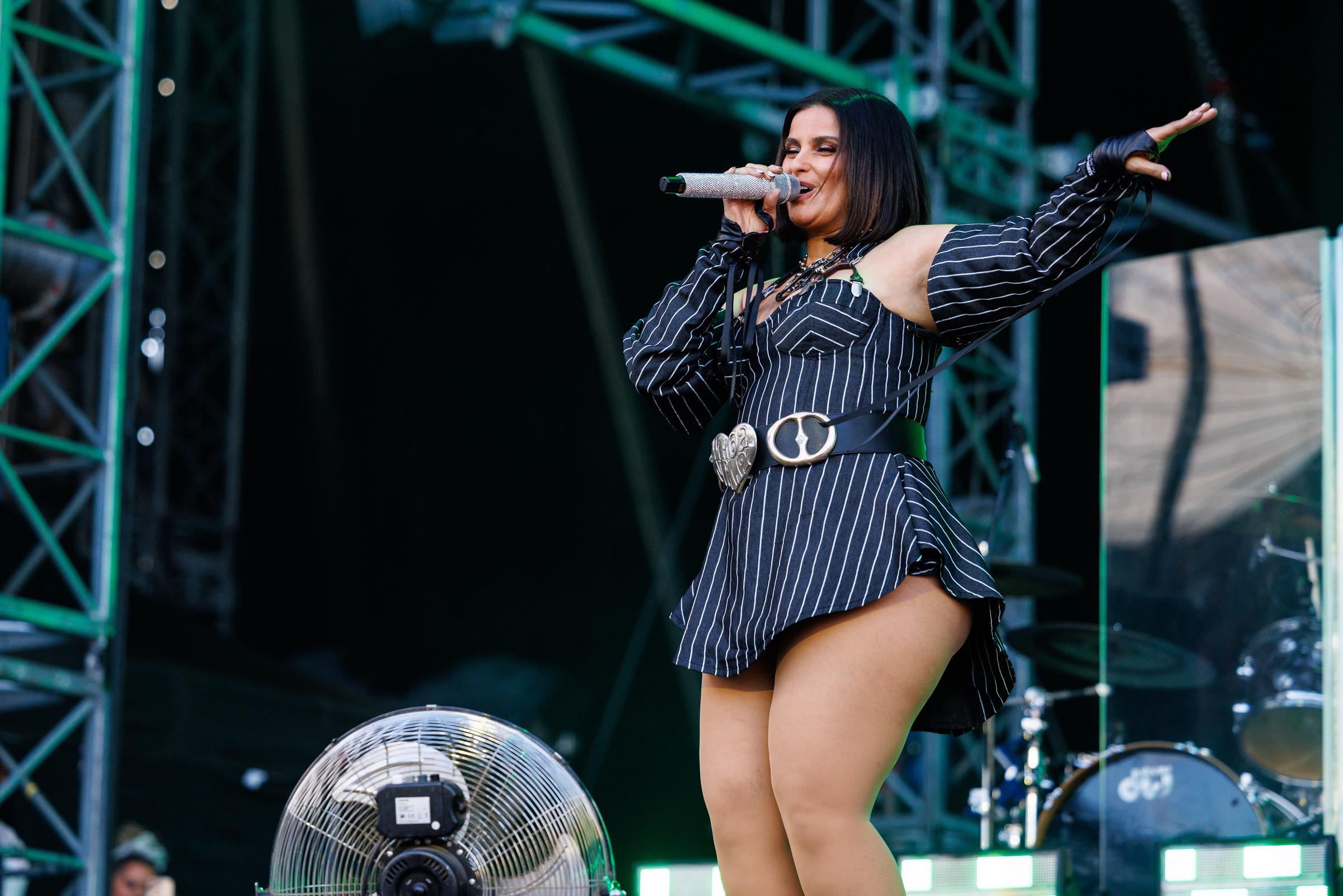 Furtado se produit sur scène dans une mini-robe asymétrique à rayures noires et blanches, avec une manche bouffante spectaculaire d'un côté. Elle accessoirise sa tenue avec une boucle de ceinture argentée originale à la taille, un collier à grosse chaîne, et ses cheveux sont lissés et coiffés en carré au niveau des épaules.