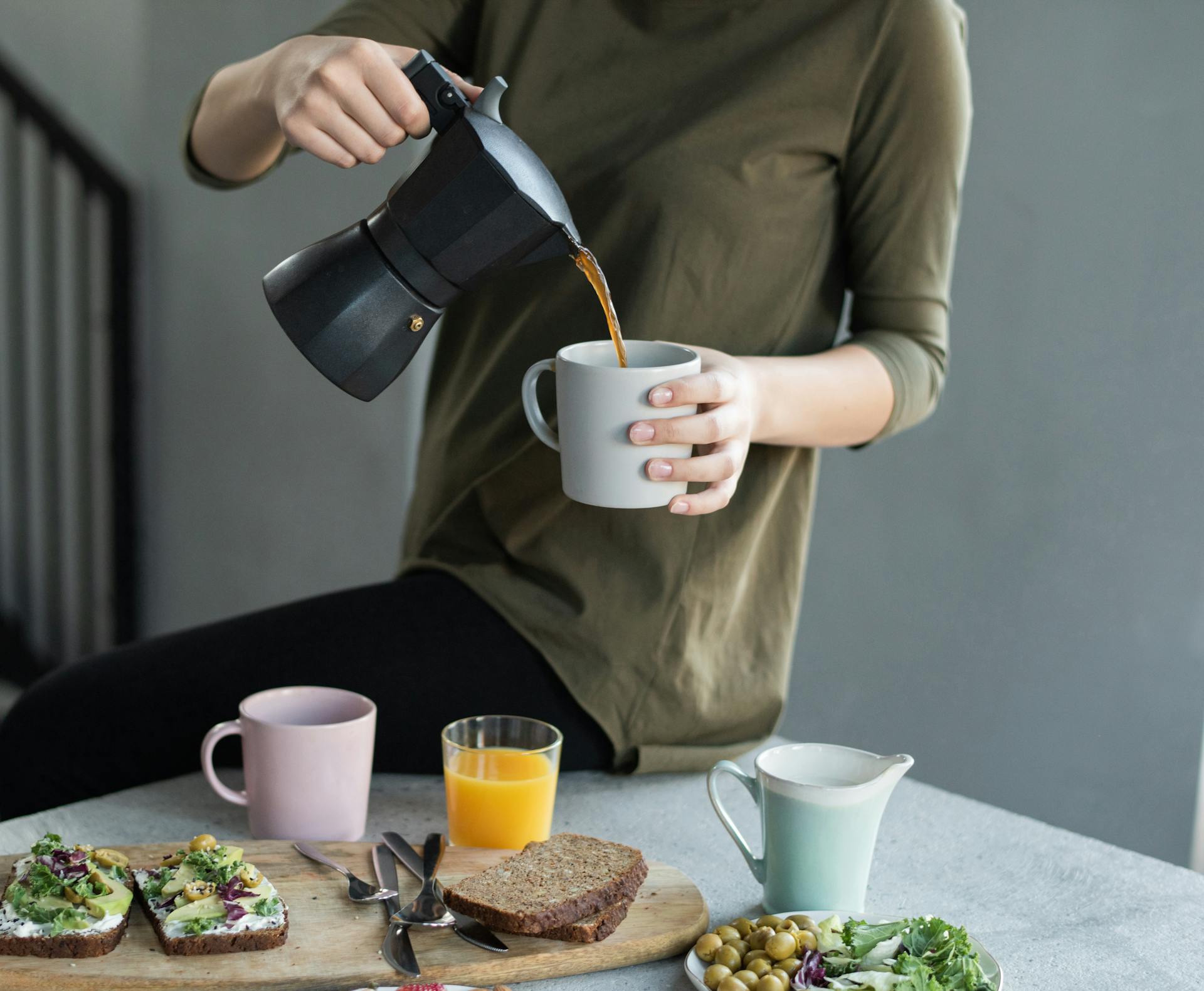Gros plan d'une femme qui verse du café dans une tasse | Source : Pexels
