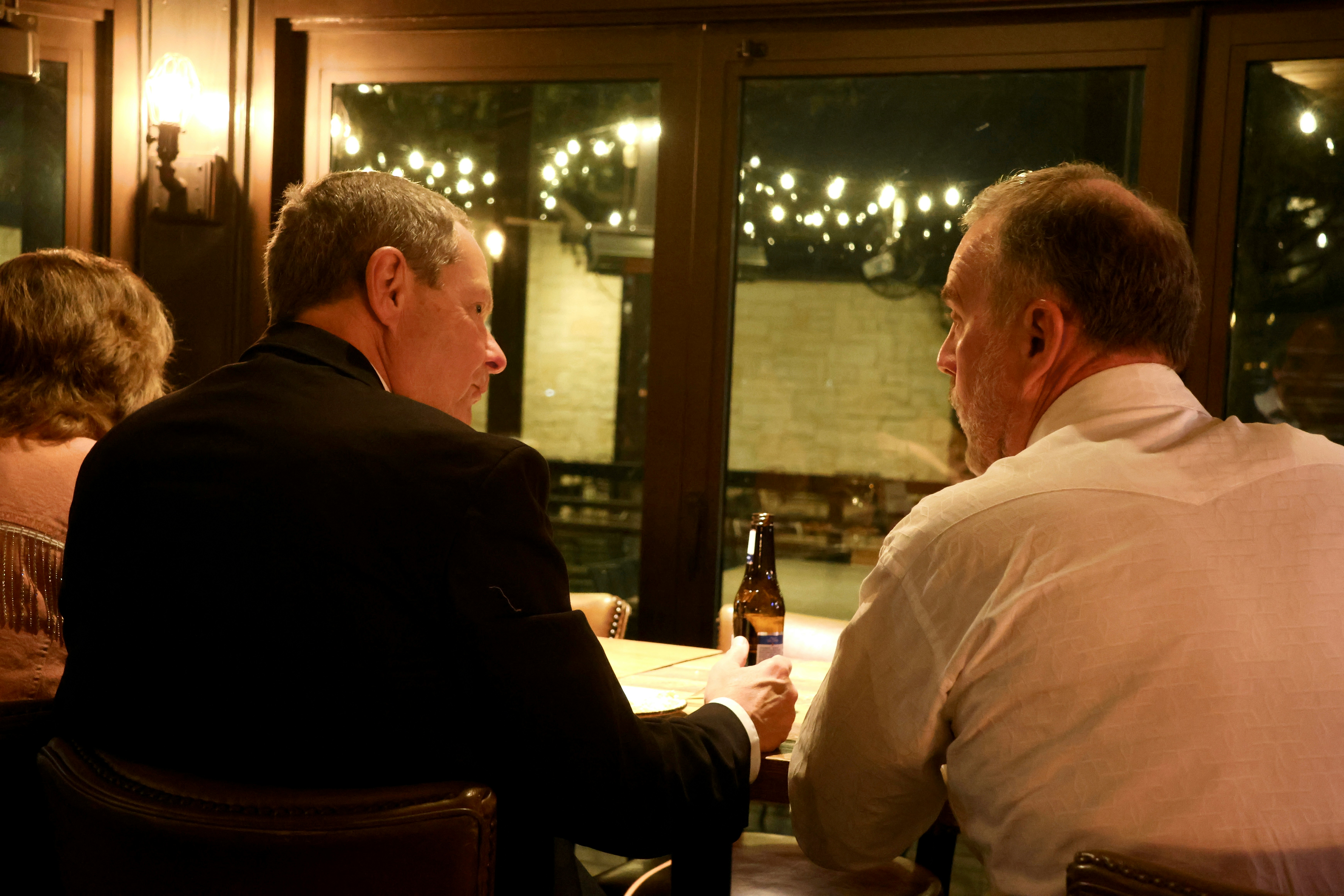 Des hommes assis à une table en train de parler | Source : Unsplash