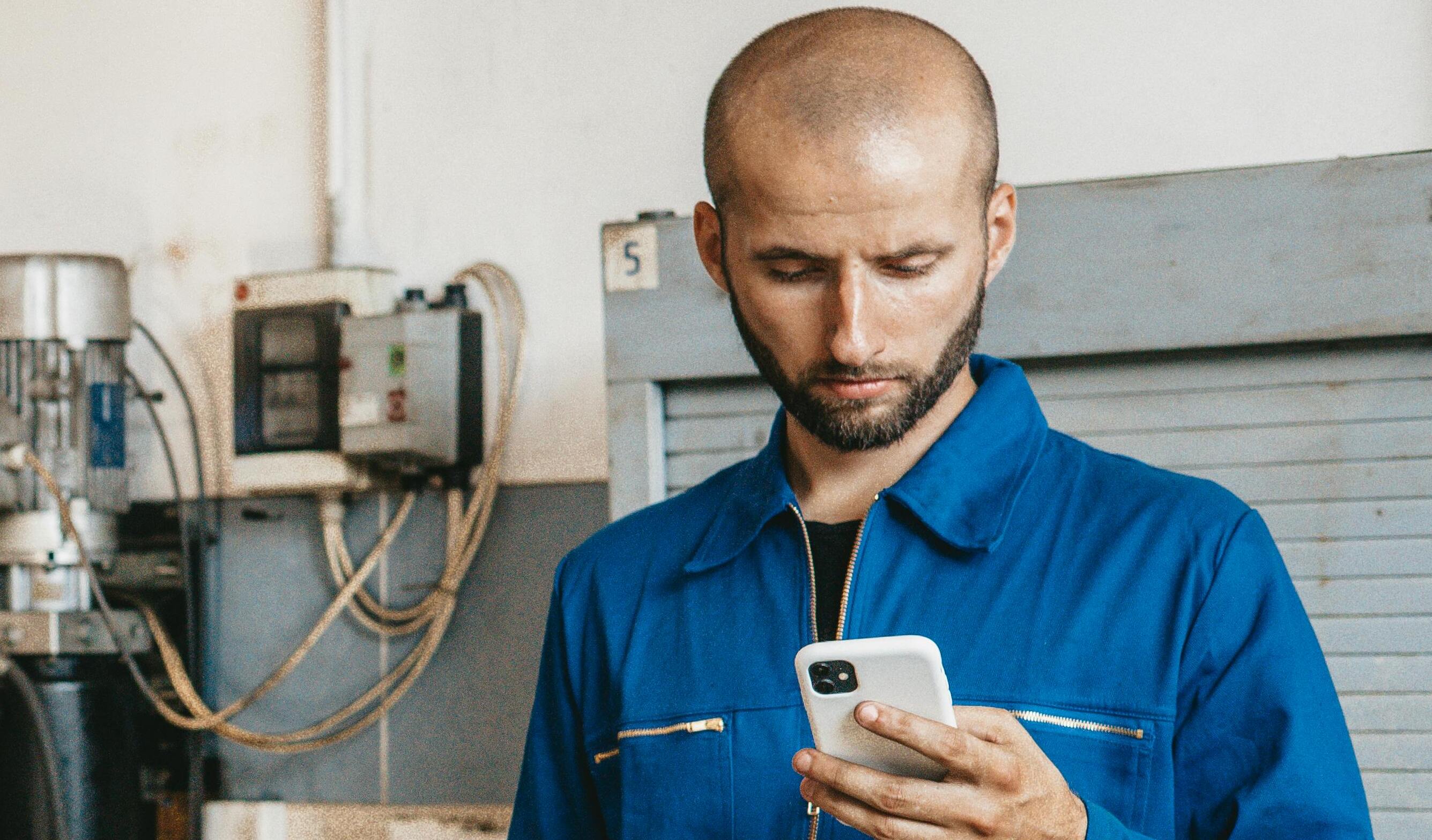Un homme en uniforme qui vérifie son téléphone | Source : Pexels