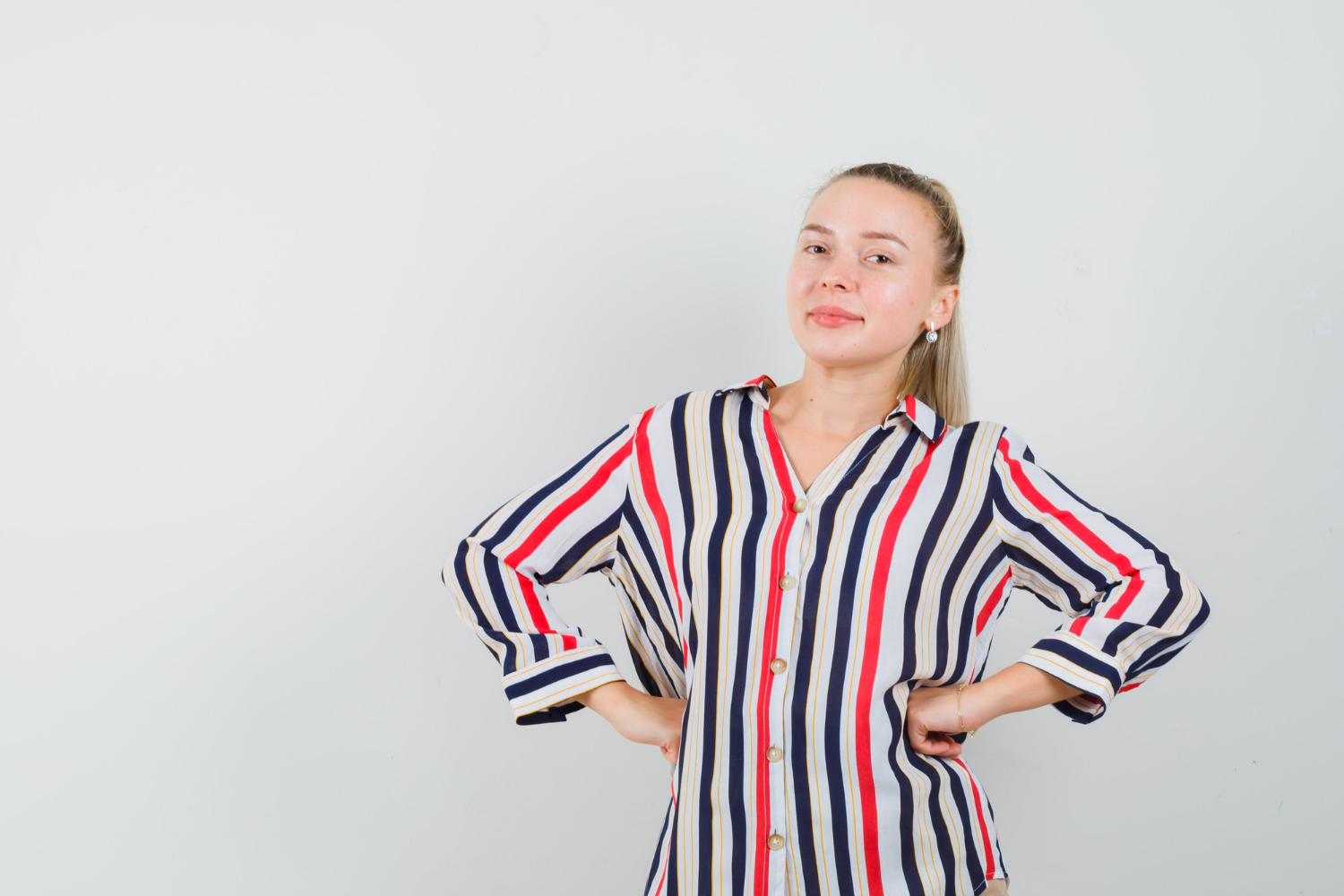 Une femme souriante qui a les mains sur les hanches | Source : Freepik