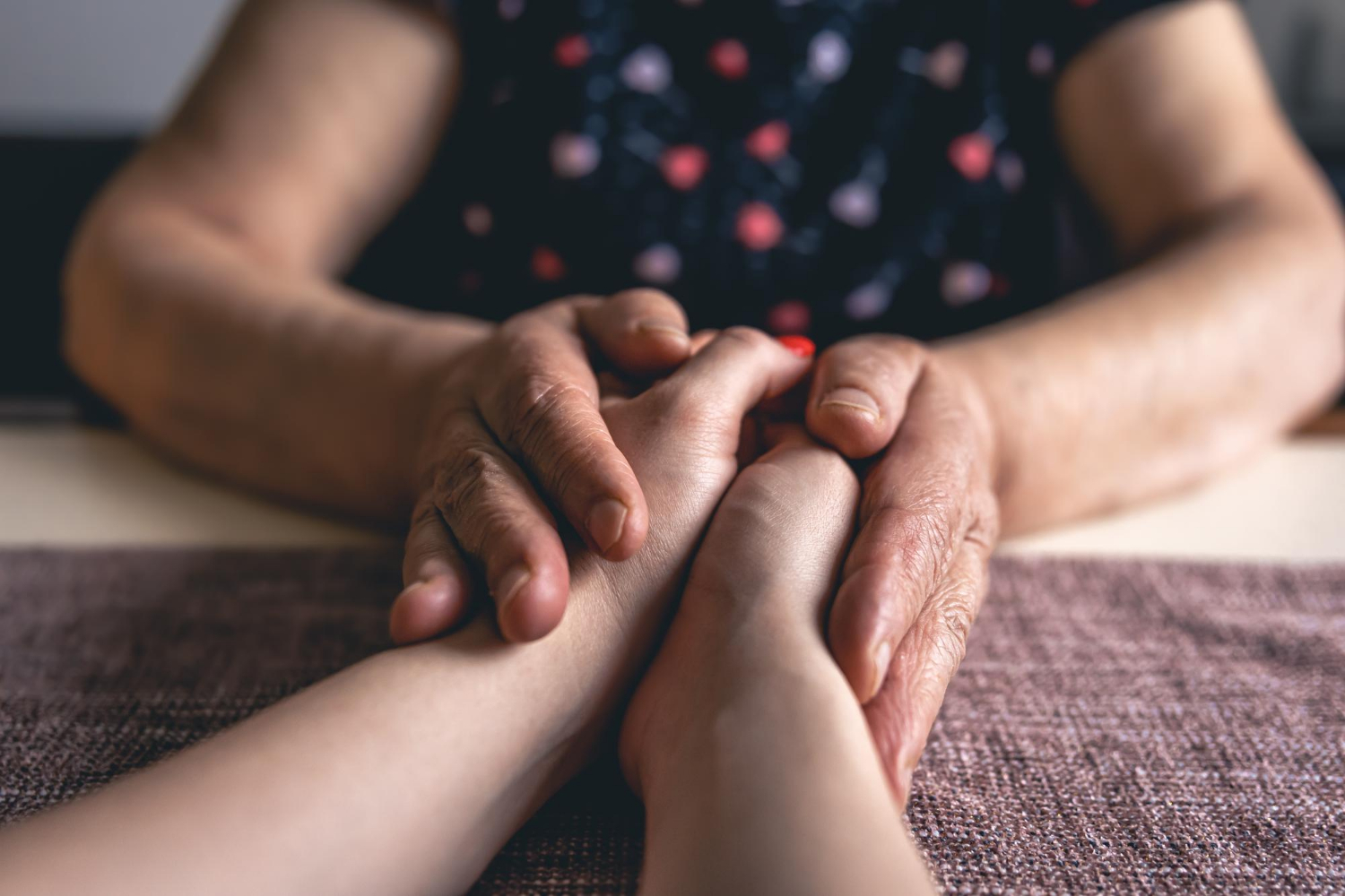 Une femme âgée tenant les mains d'une jeune femme | Source : Freepik