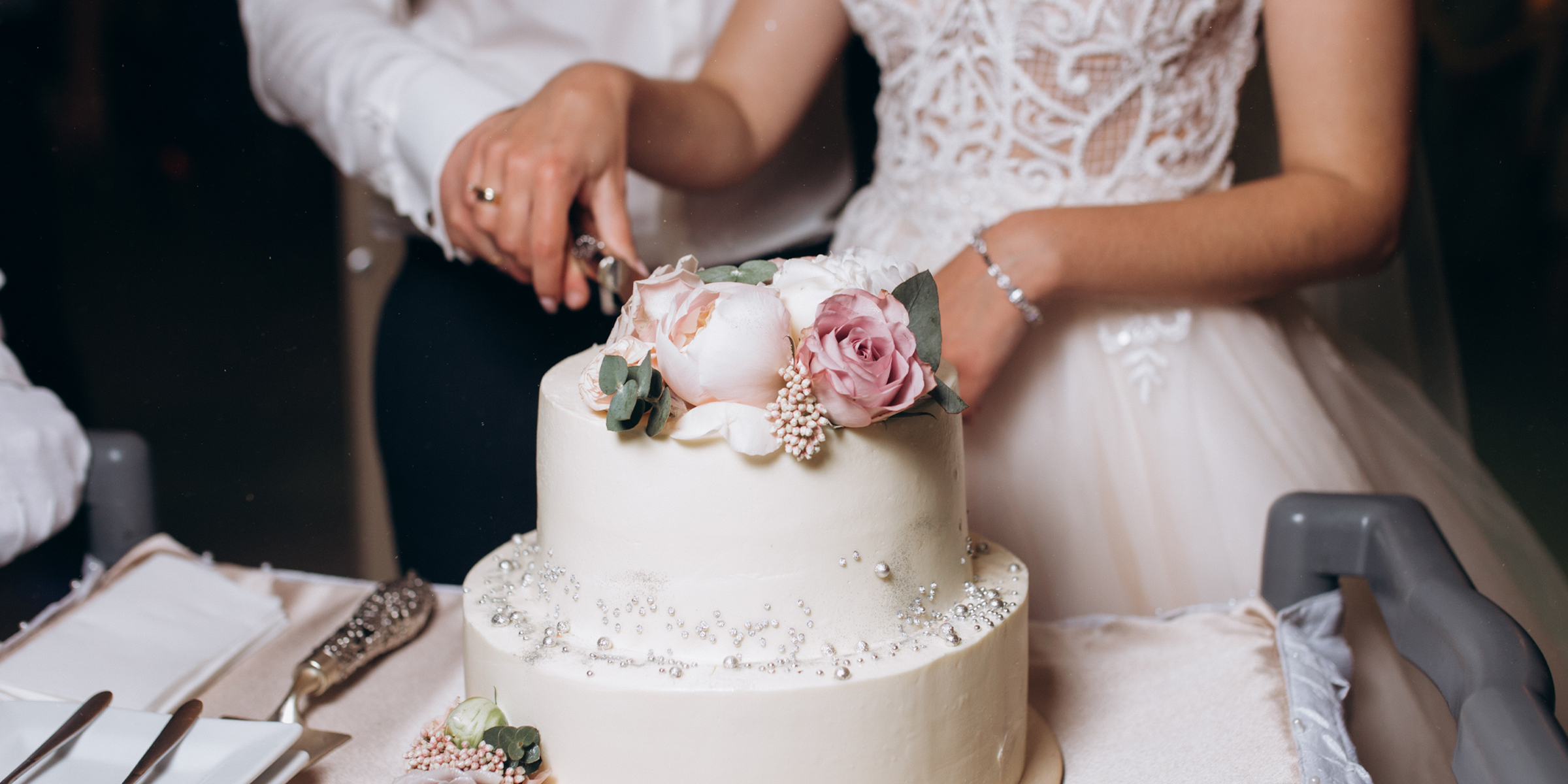 Une mariée et un marié coupant un gâteau | Source : Freepik