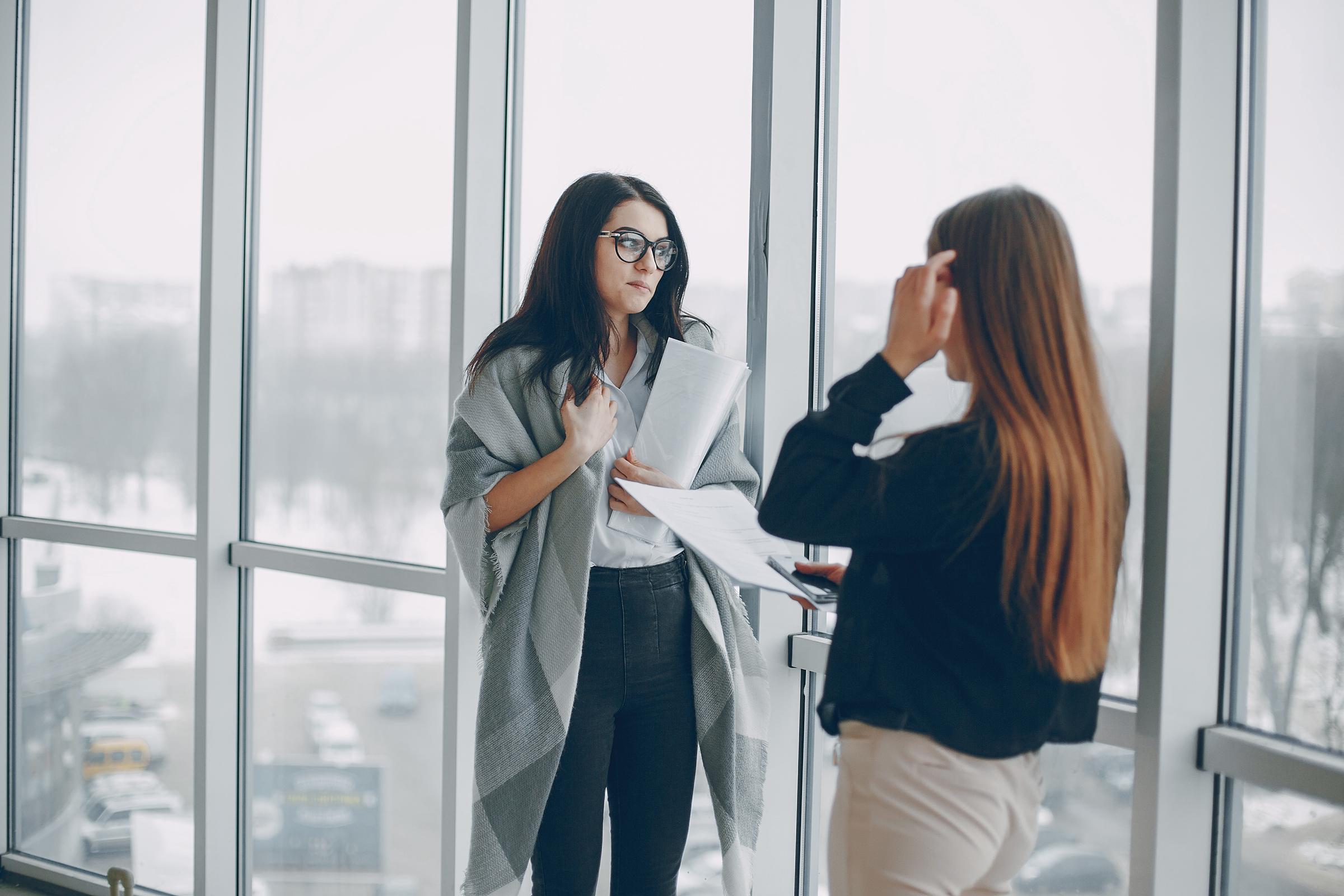 Deux femmes discutent sur leur lieu de travail | Source : Freepik