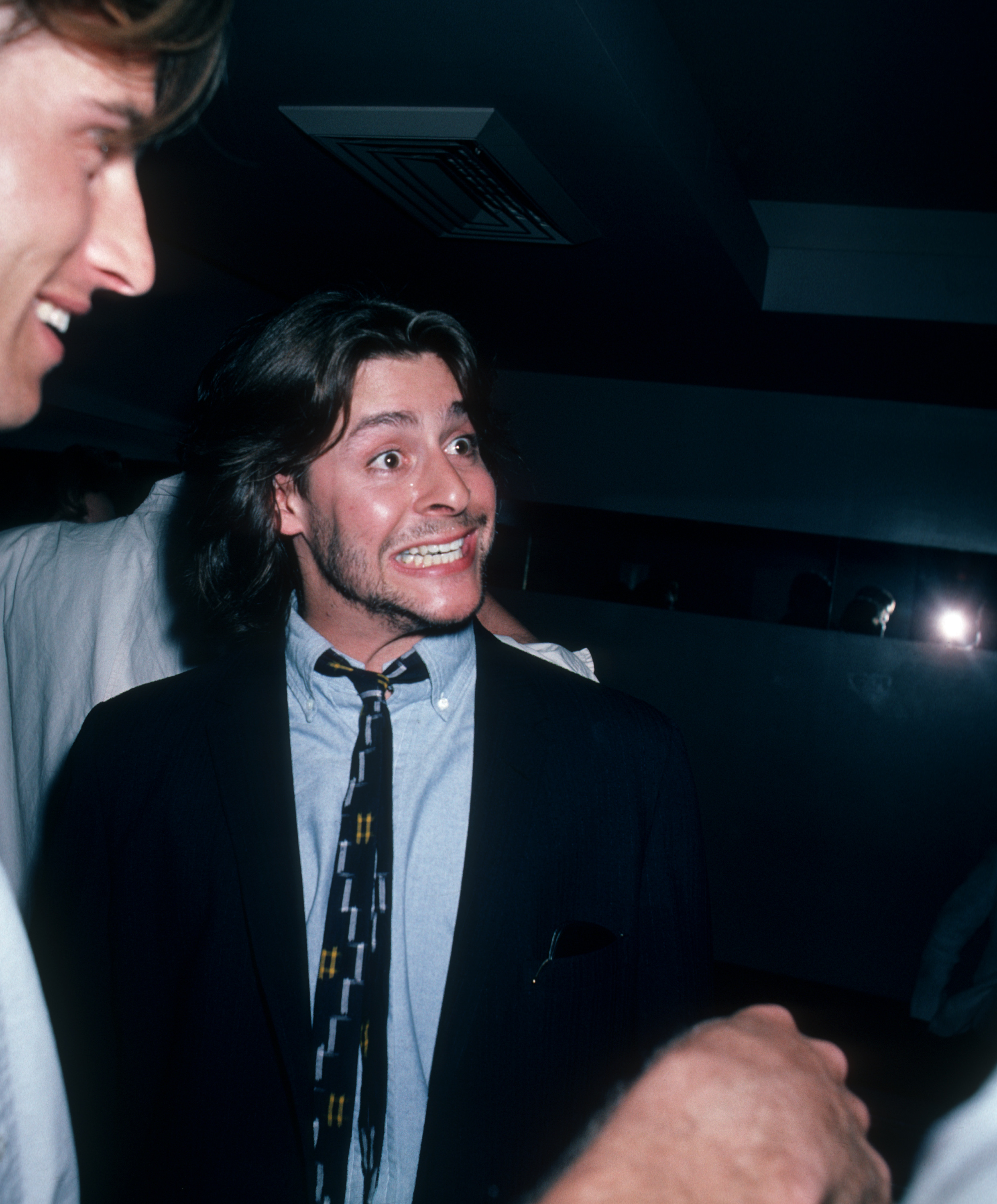 Arborant une expression animée, les yeux écarquillés, au cours d'une conversation animée, l'acteur a passé une soirée à l'exposition d'art de Peter Max chez Marylou's à New York, le 8 mai 1986. | Source : Getty Images
