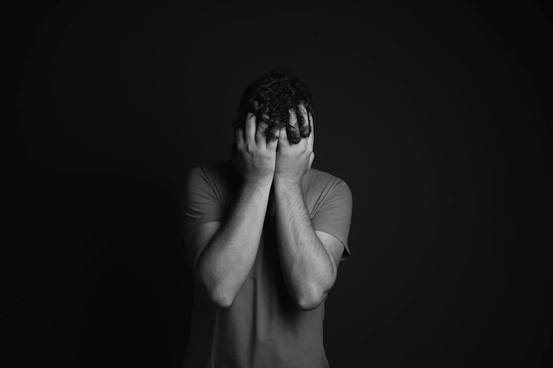 Un homme triste se couvrant le visage | Source : Pexels