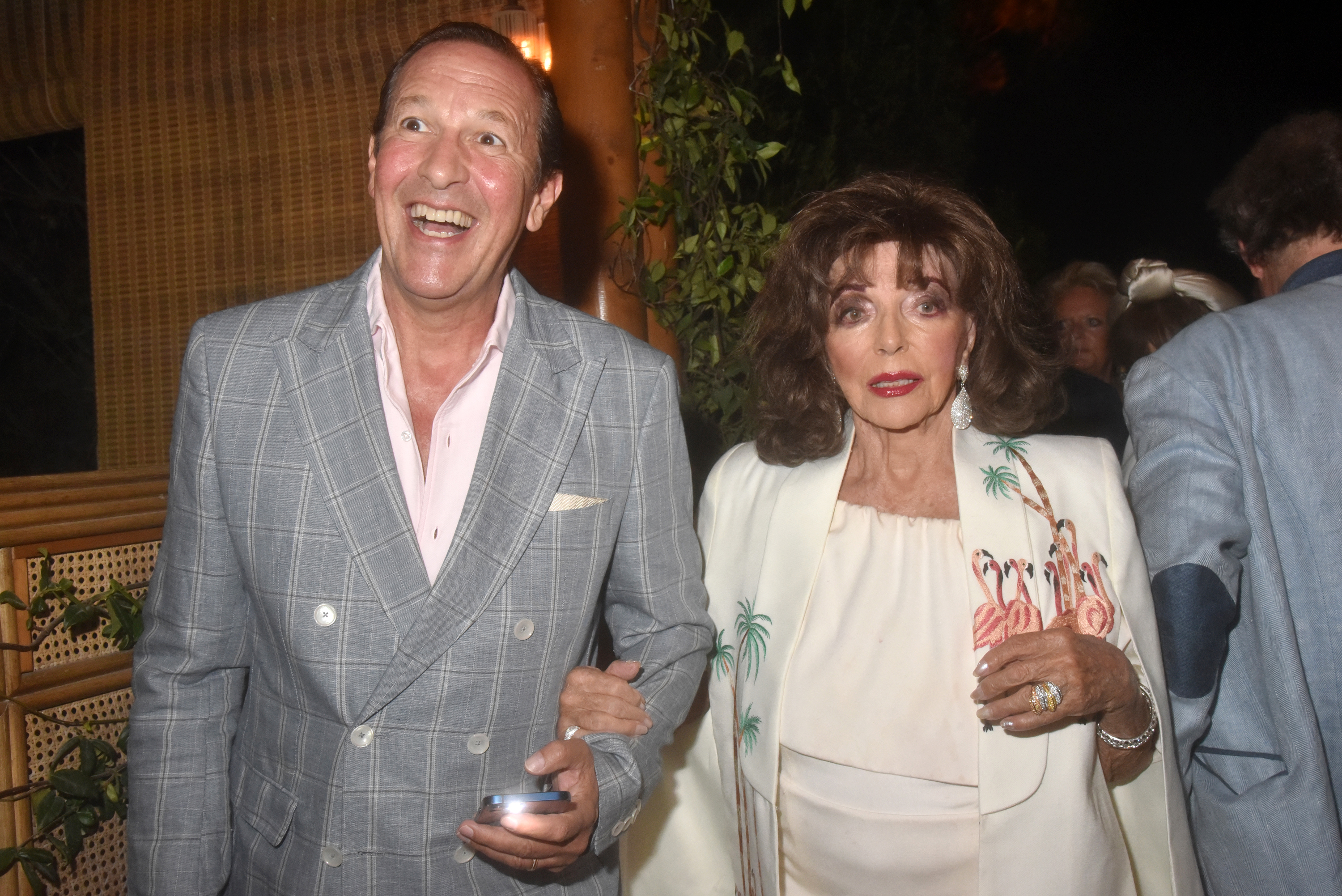 Percy Gibson et Joan Collins lors du dîner d'anniversaire de Frédéric Merlin, le 1er août 2025, à Saint-Tropez, en France. | Source : Getty Images