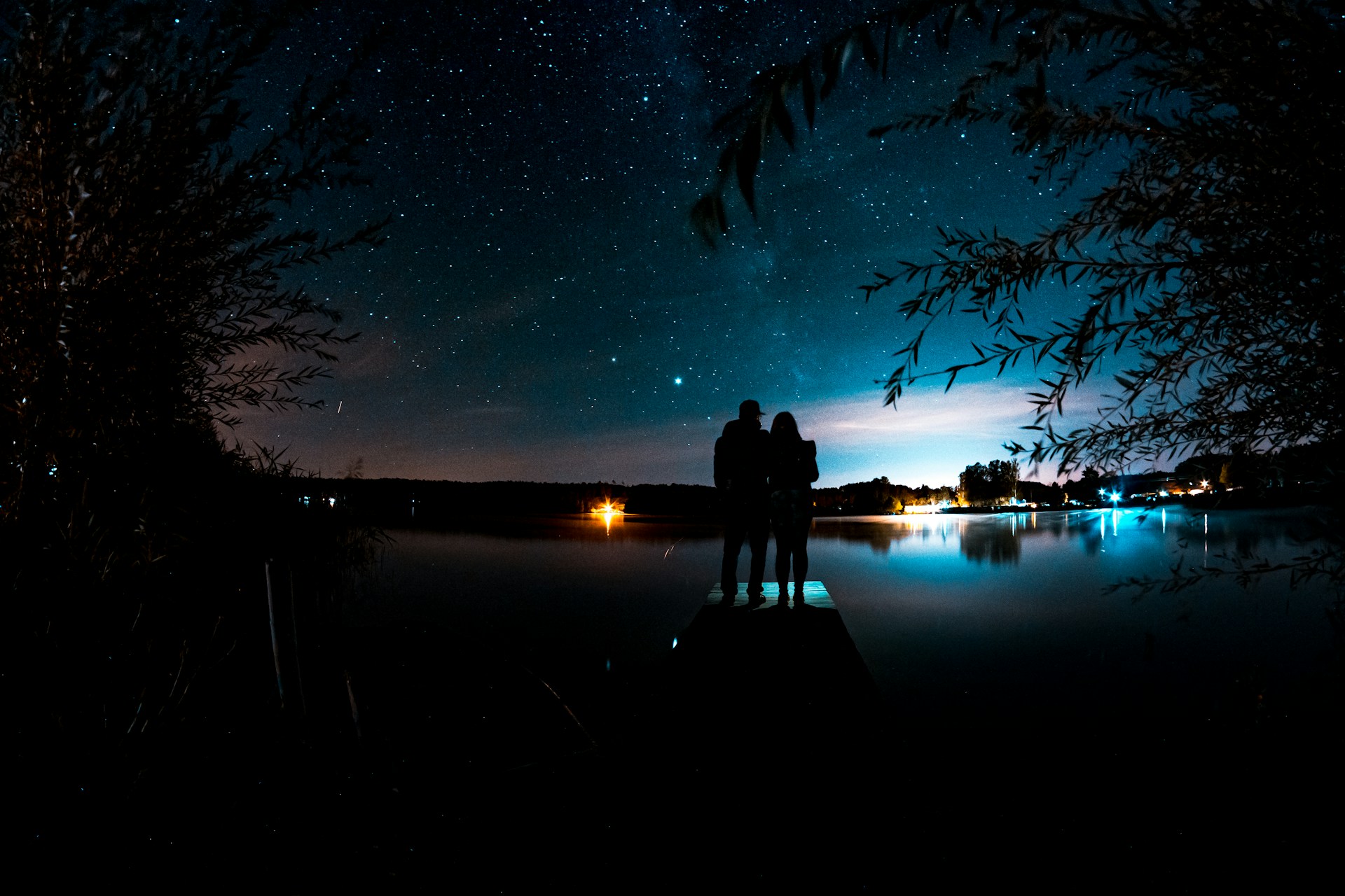 Un jeune couple admire les étoiles depuis une jetée lors d'une soirée pittoresque | Source : Unsplash
