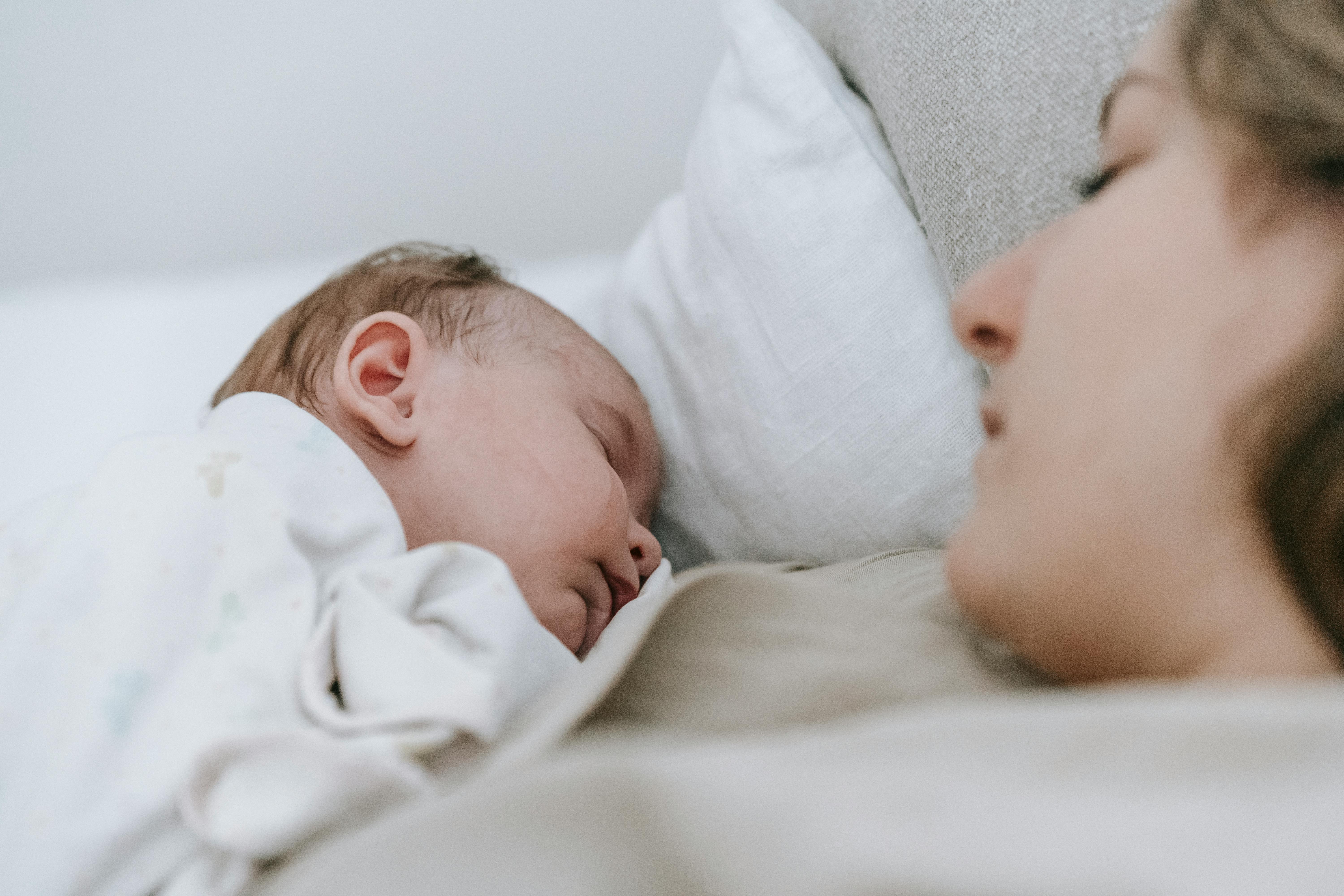 Une femme qui dort avec un bébé | Source : Pexels