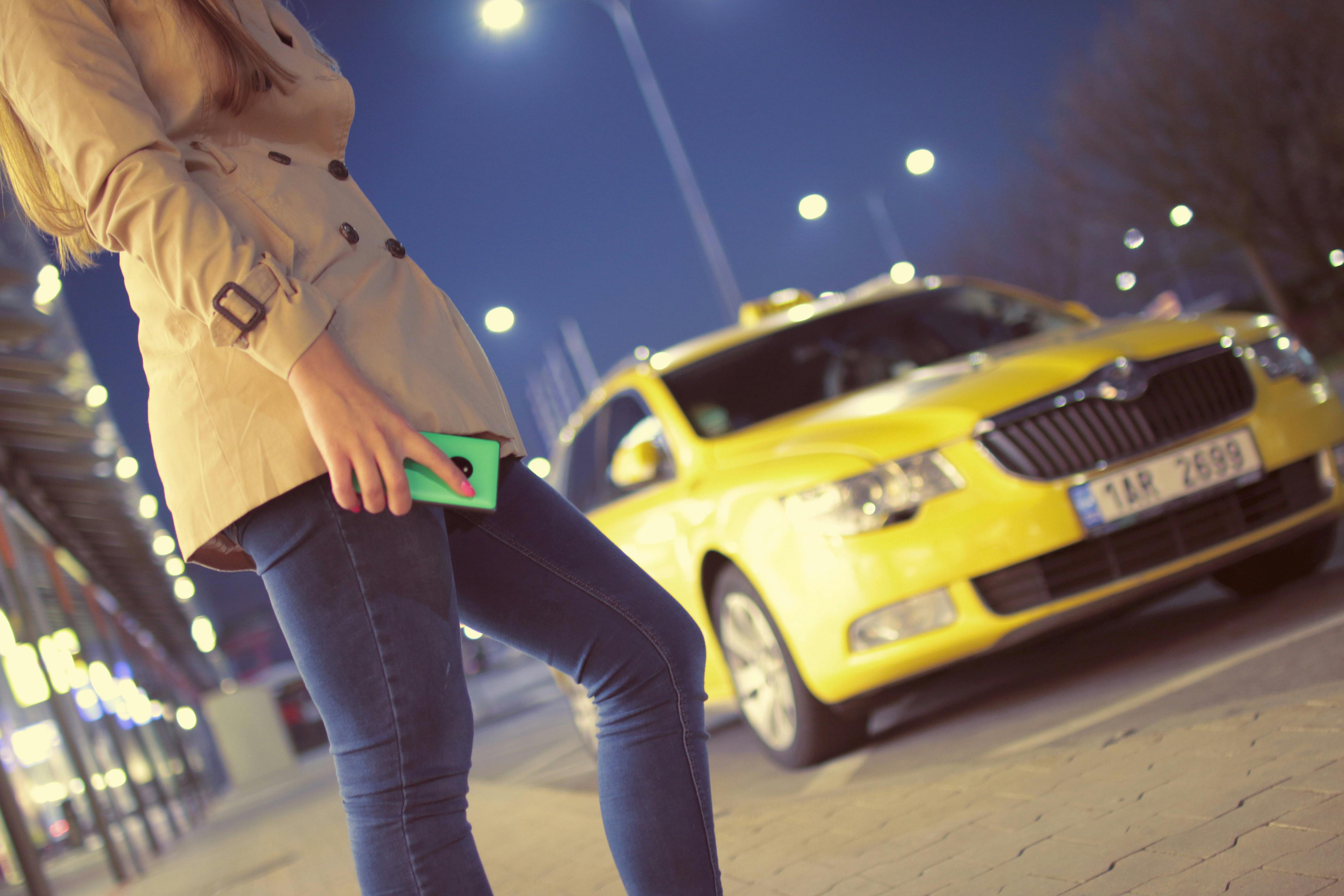 Une femme debout sur le trottoir près d'un taxi | Source : Pexels