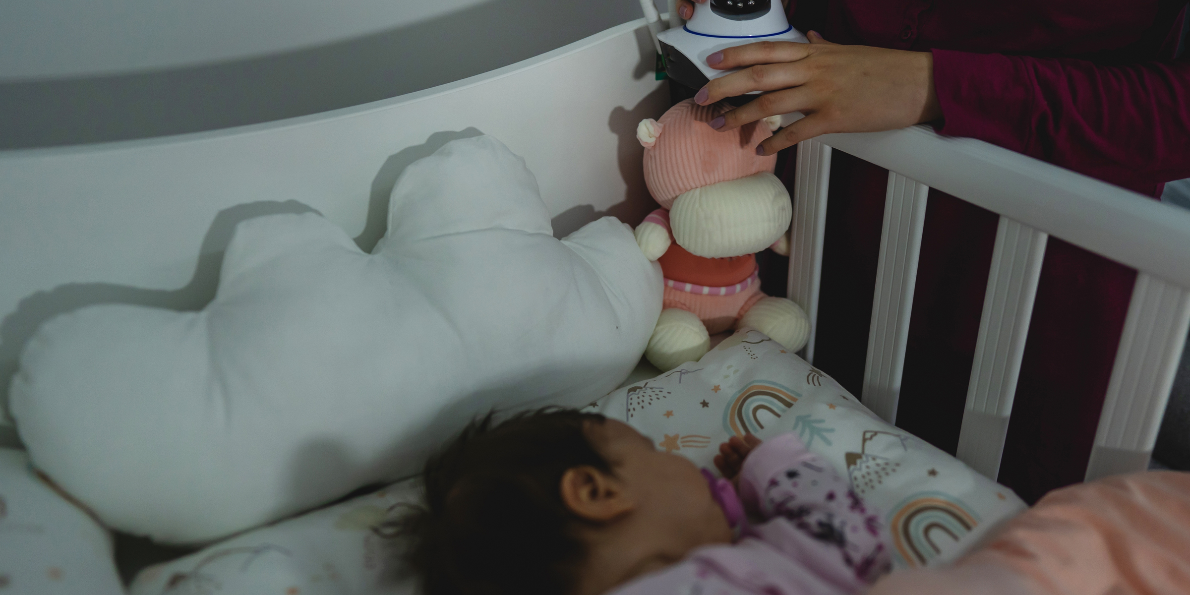 Une femme plaçant une caméra sur le berceau d'un bébé | Source : Shutterstock