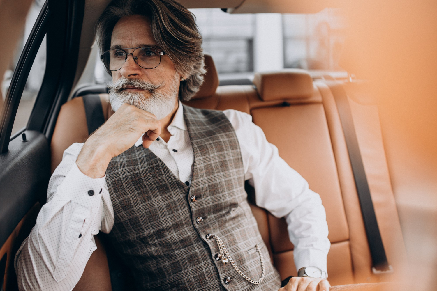 Un élégant homme âgé assis dans sa voiture | Source : Freepik