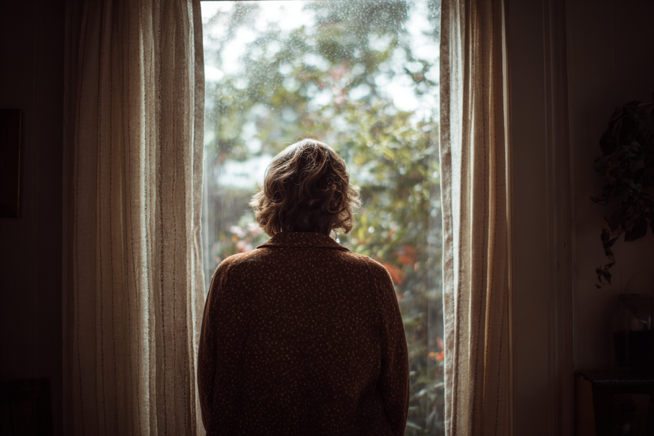 Une femme qui regarde par la fenêtre | Source : Midjourney