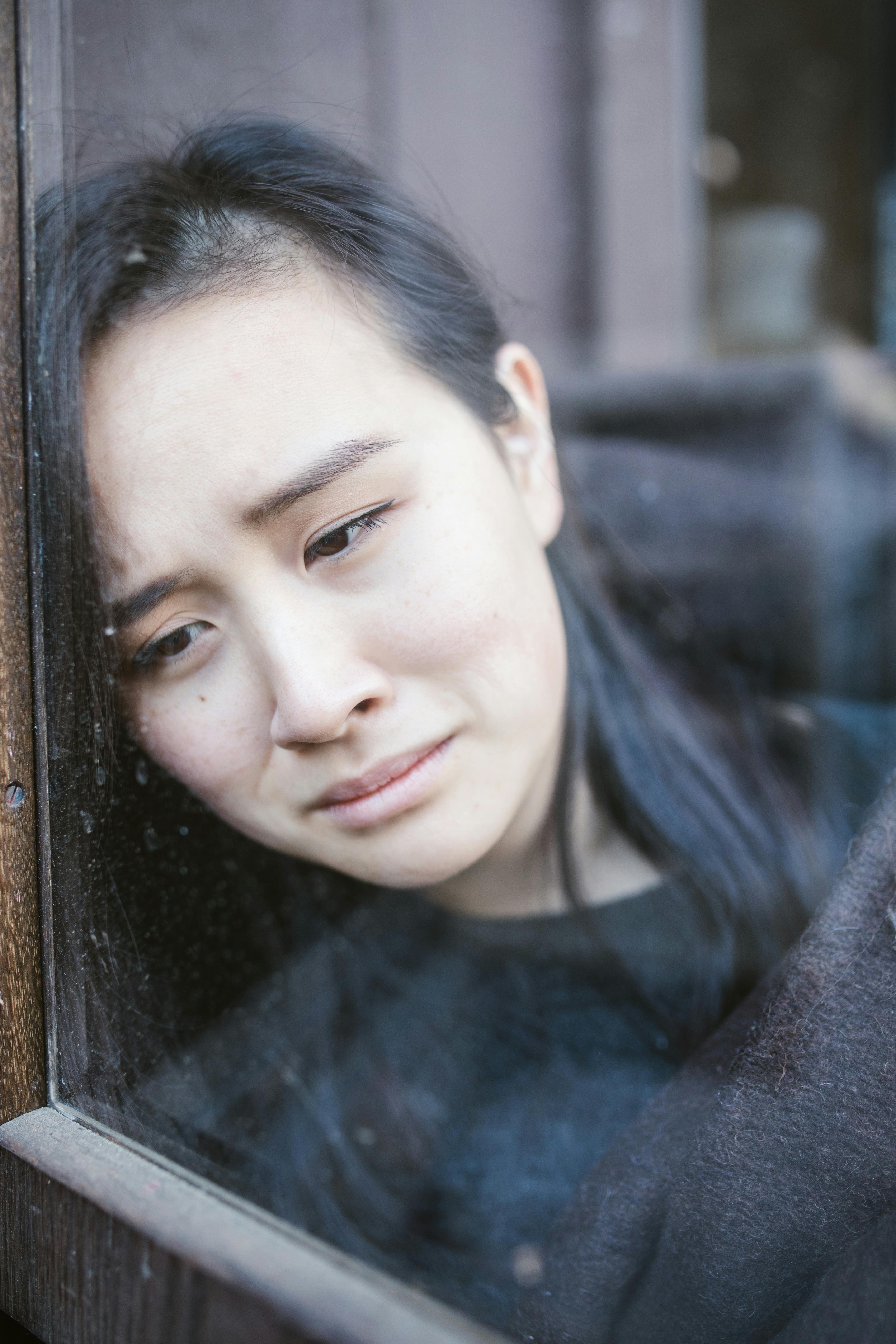 Une femme triste qui regarde par la fenêtre | Source : Pexels