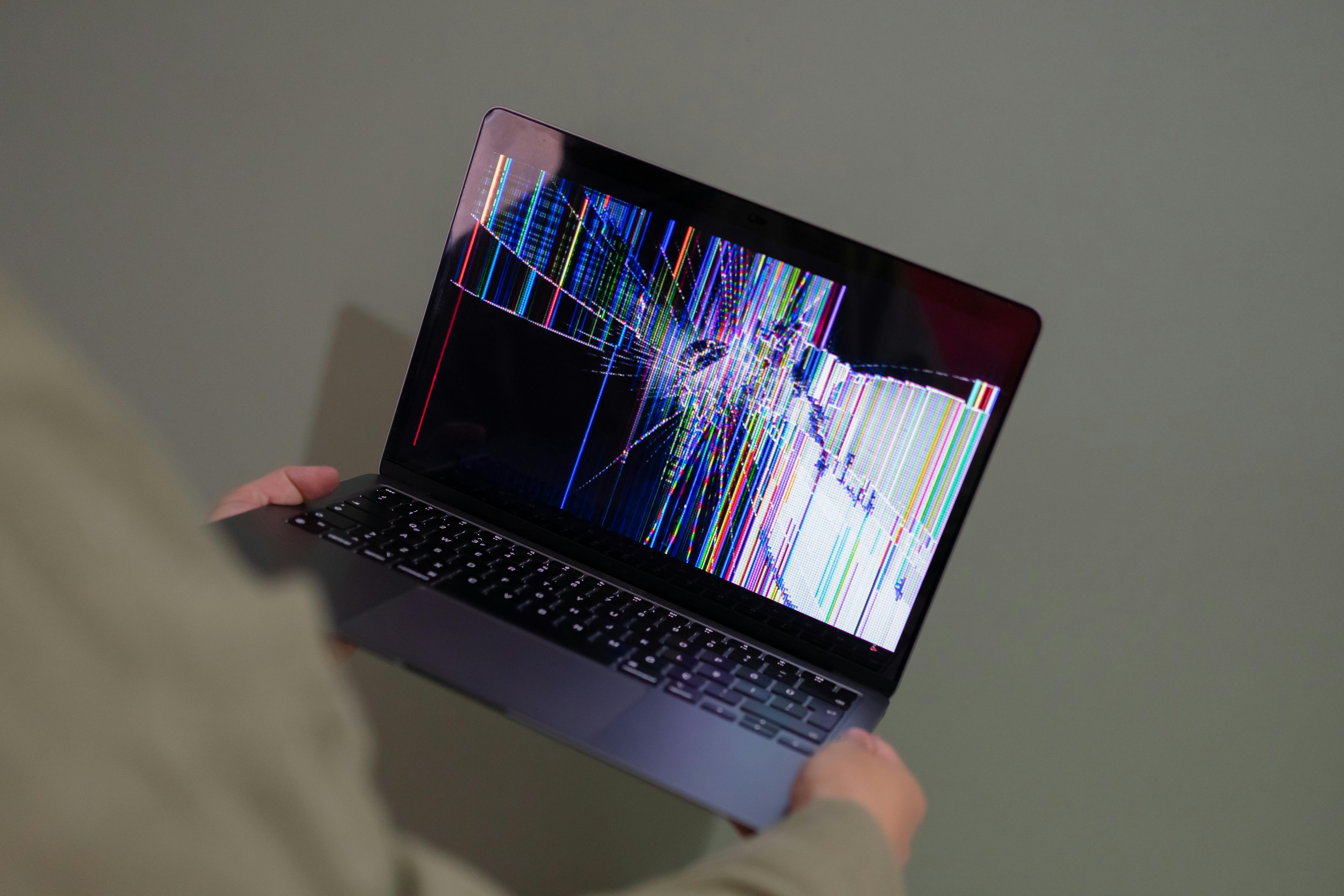 Une personne tenant un ordinateur portable cassé | Source : Pexels