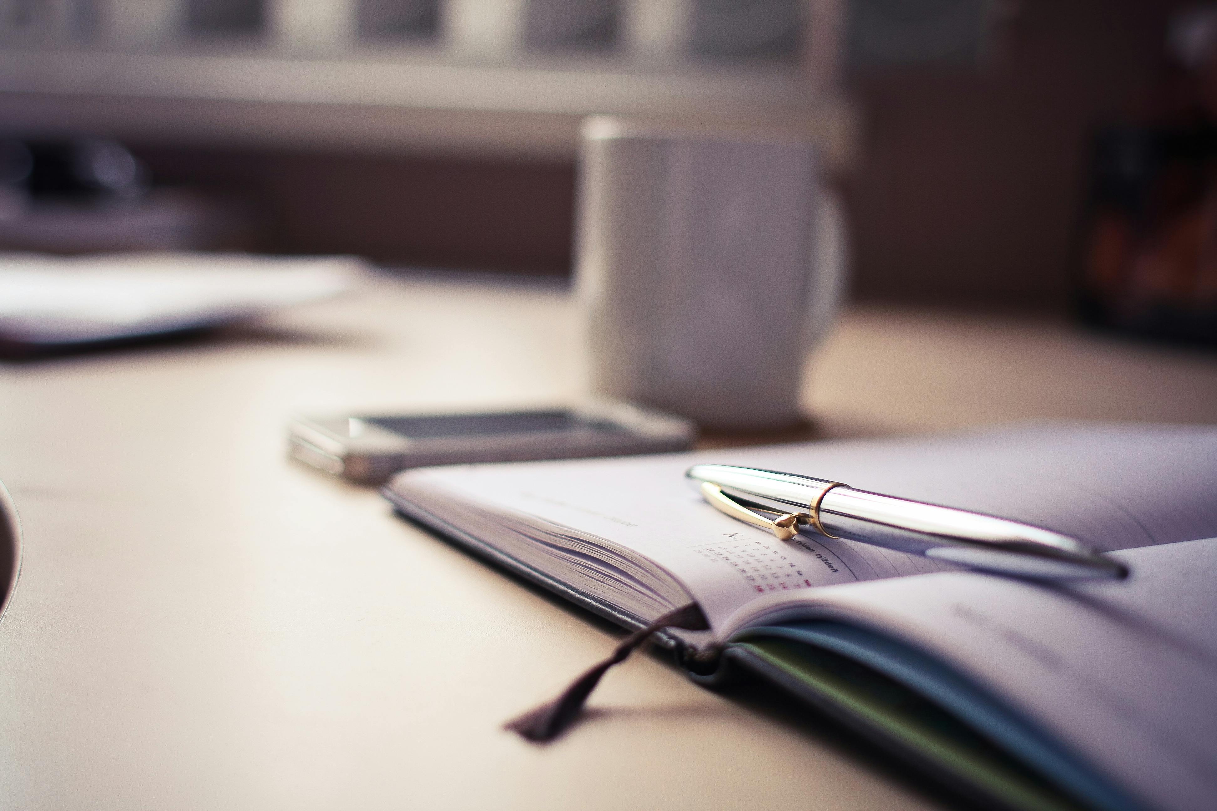 Un stylo et un cahier sur une table | Source : Pexels