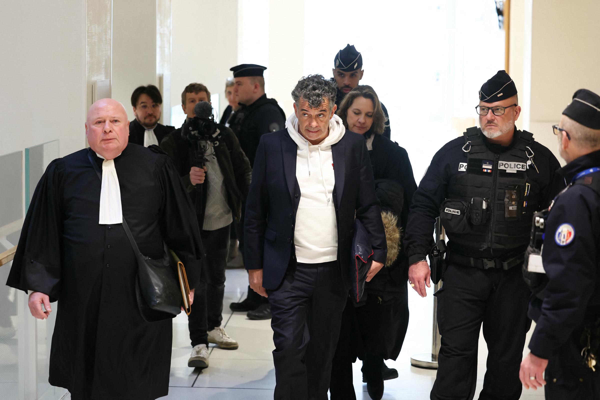 Le présentateur de télévision et agent immobilier français Stéphane Plaza (au centre), accusé d'actes de violence à l'encontre de deux anciennes compagnes, arrive pour le verdict de son procès, accompagné de ses avocats Hélène Plumet (3e à droite) et Carlo Alberto Brusa (à gauche), au tribunal correctionnel de Paris, le 18 février 2025 I Source : Getty Images