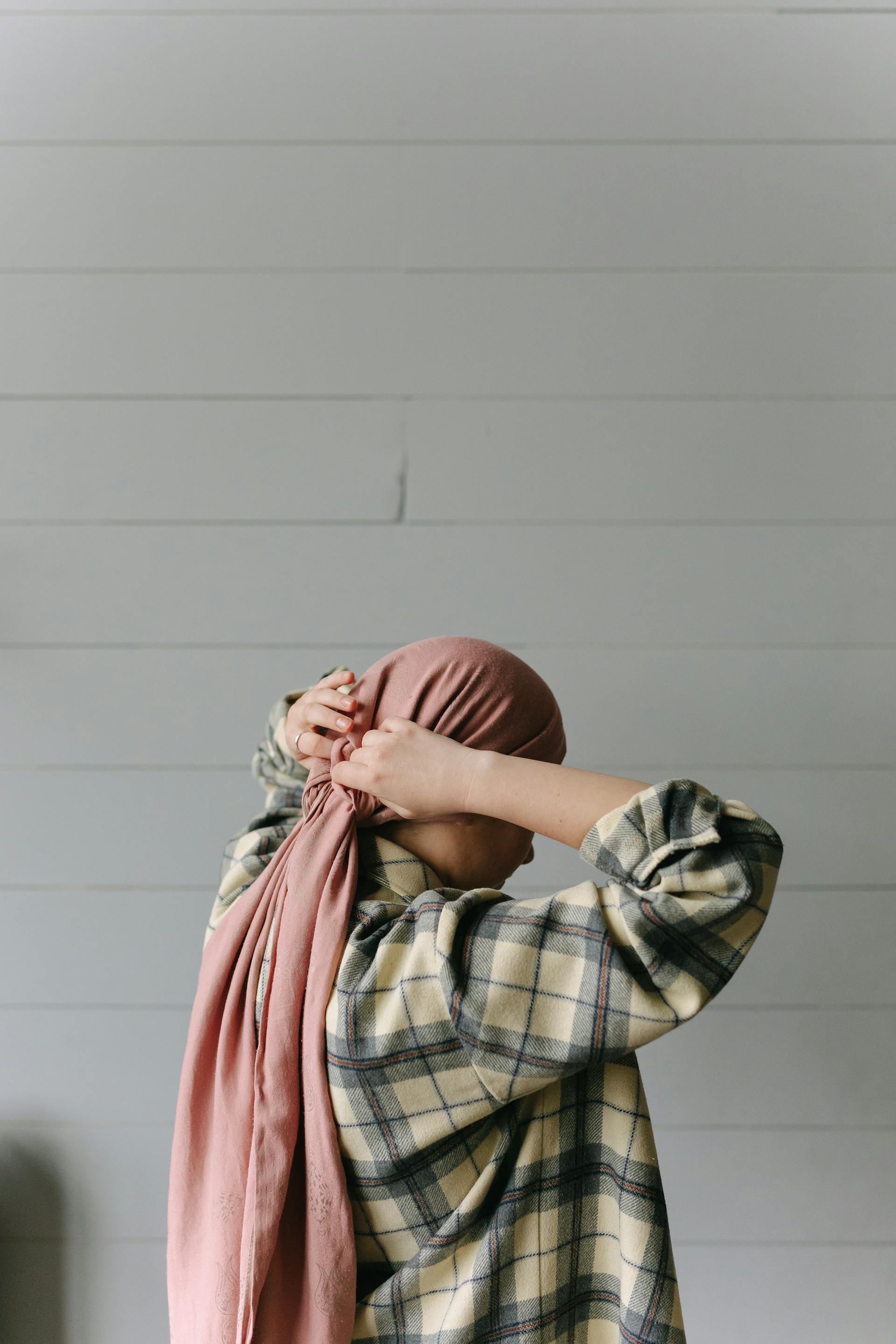 Une femme qui met un foulard | Source : Pexels