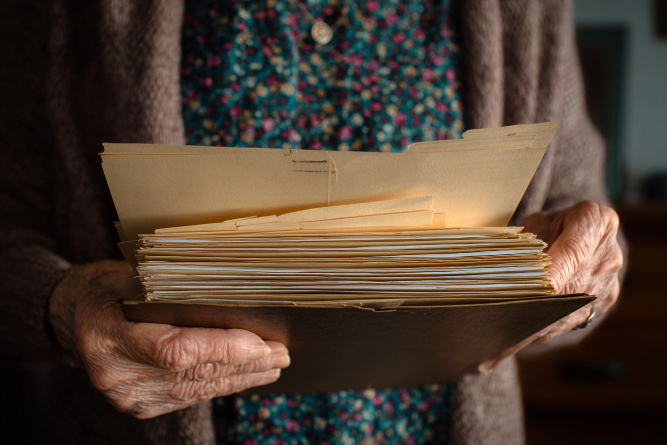 Une femme âgée tenant des dossiers | Source : Midjourney