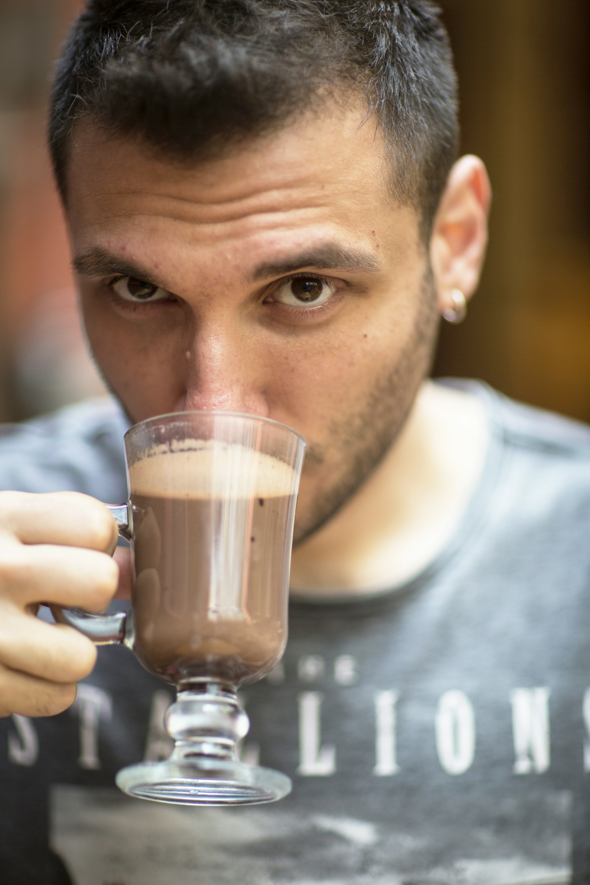 Un homme regardant fixement tout en buvant une boisson | Source : Unsplash