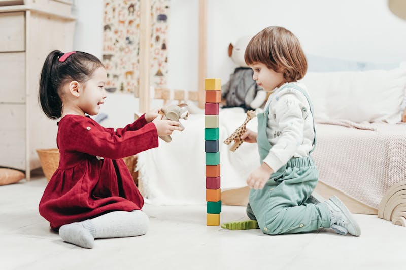 Un petit garçon et une petite fille jouant avec des blocs dans leur chambre | Source : Pexels