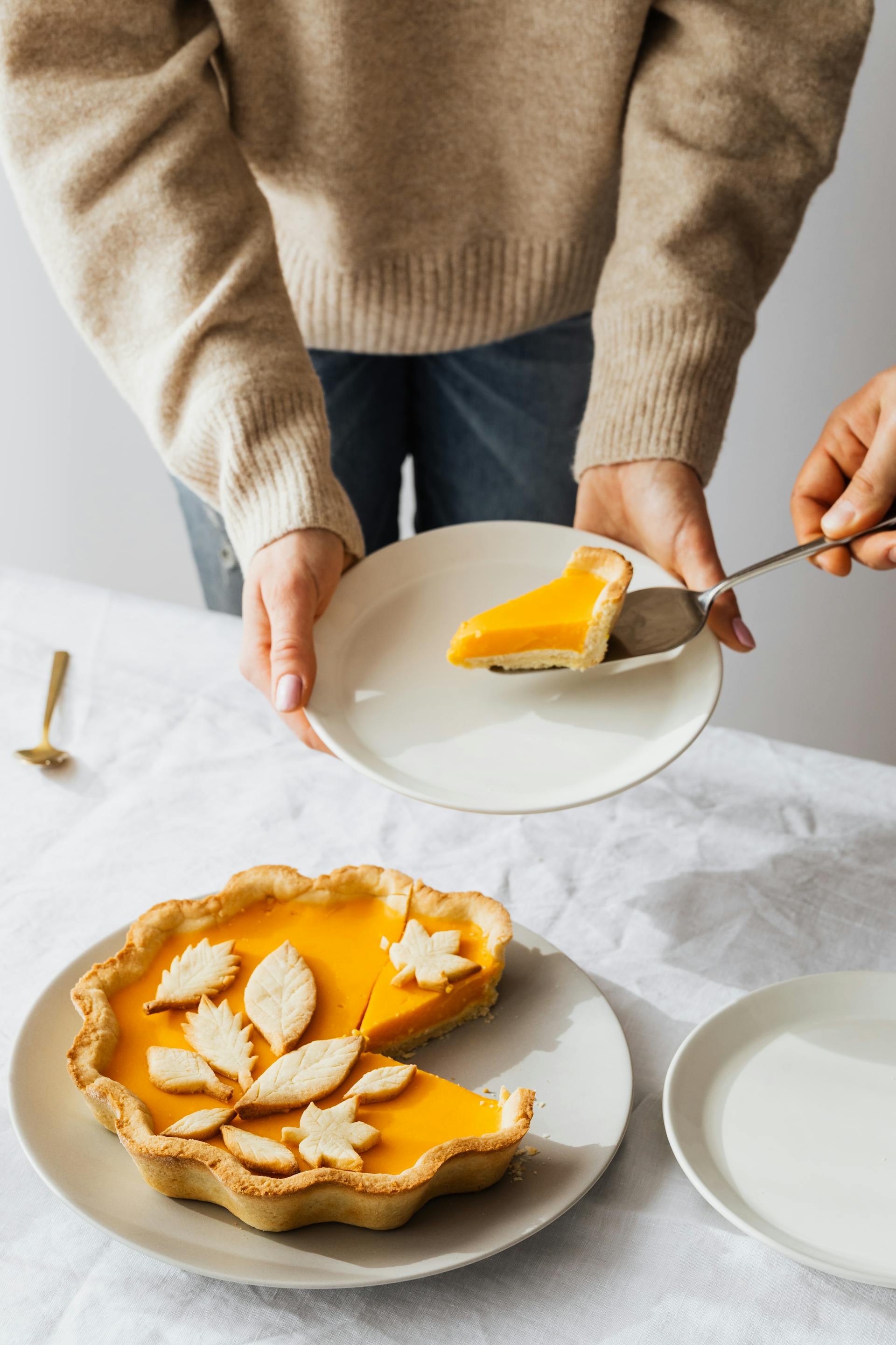 Une part de tarte au citron sur une assiette tenue par une personne | Source : Pexels