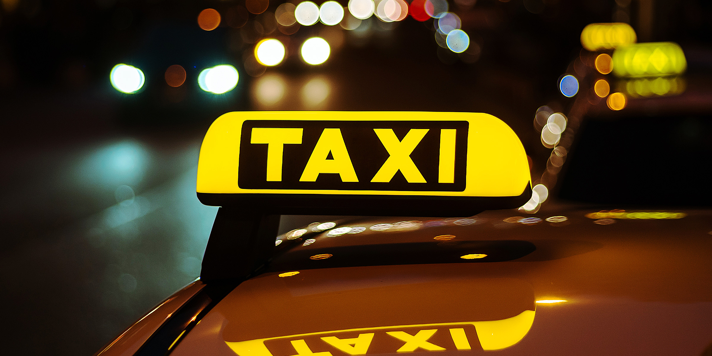 Un panneau de taxi jaune et noir placé sur le toit d'une voiture | Source : Freepik