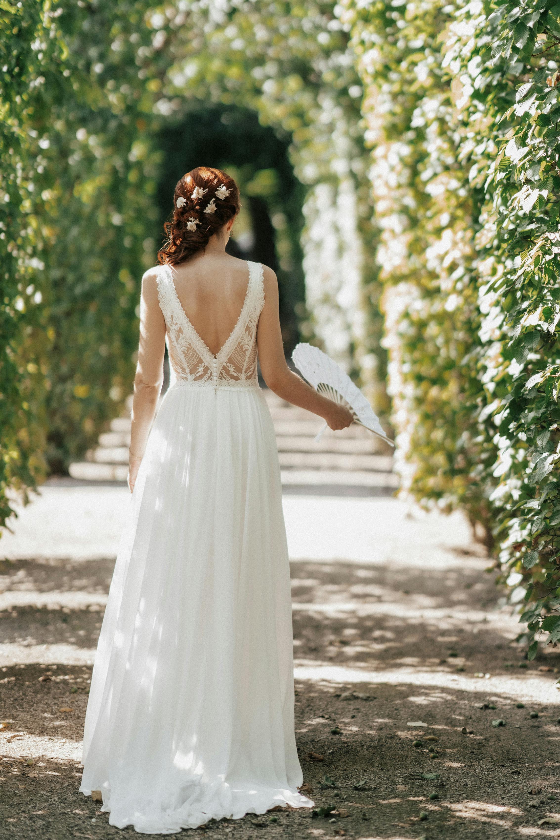 Mariée dans une élégante robe en dentelle dans une arche de jardin | Source : Pexels