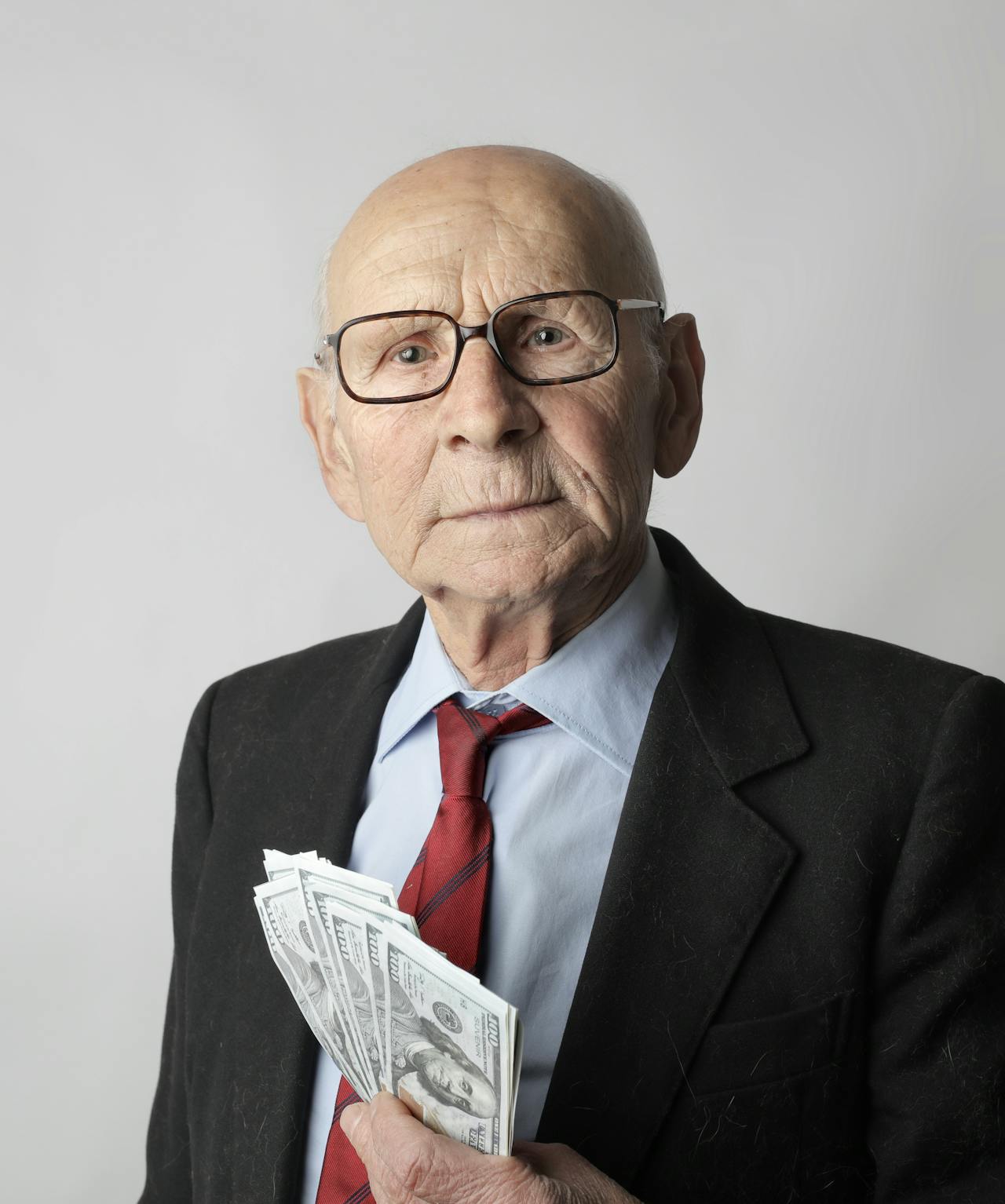 Un homme riche et âgé tenant de l'argent | Source : Pexels