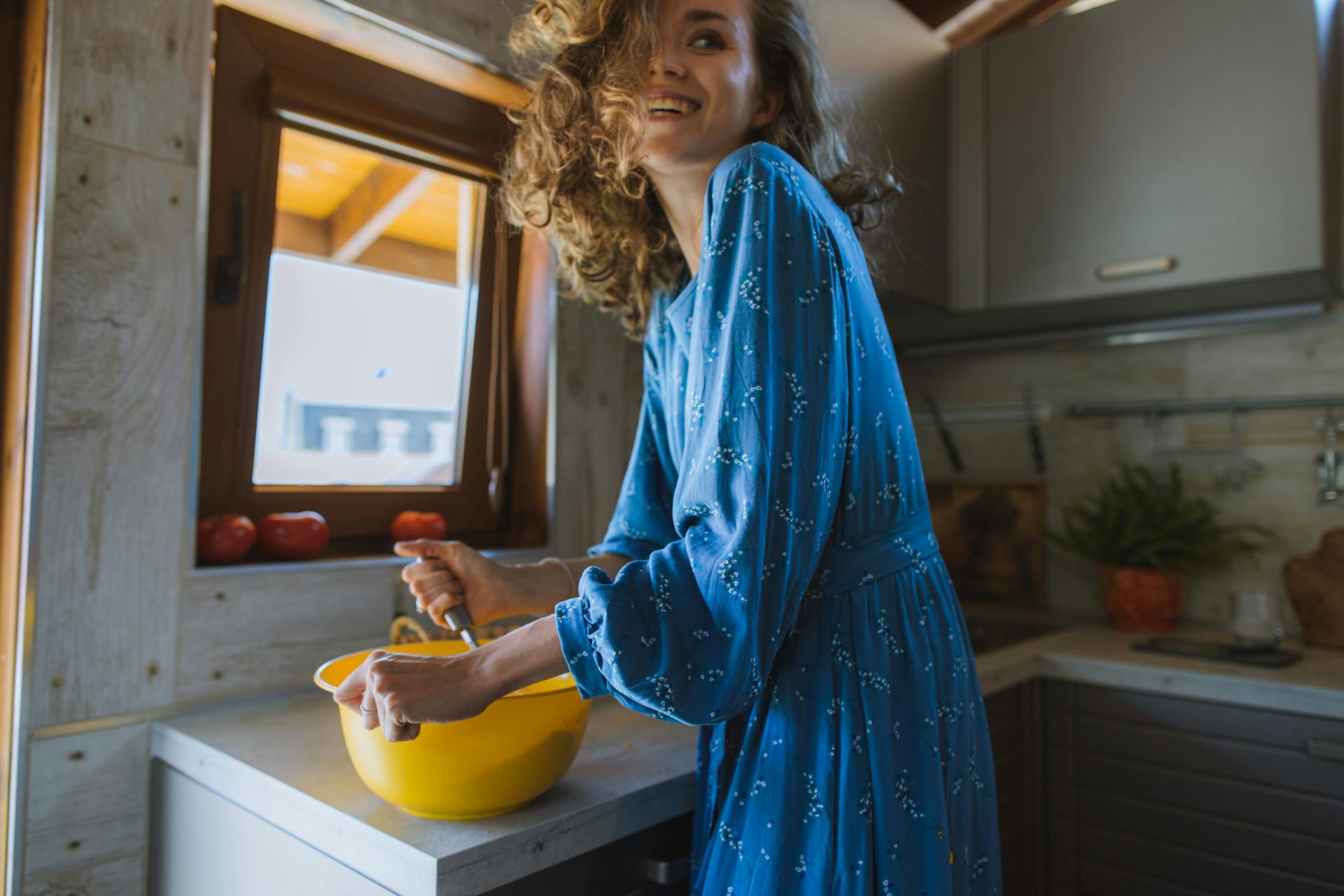 Une femme souriante en train de cuisiner | Source : Pexels