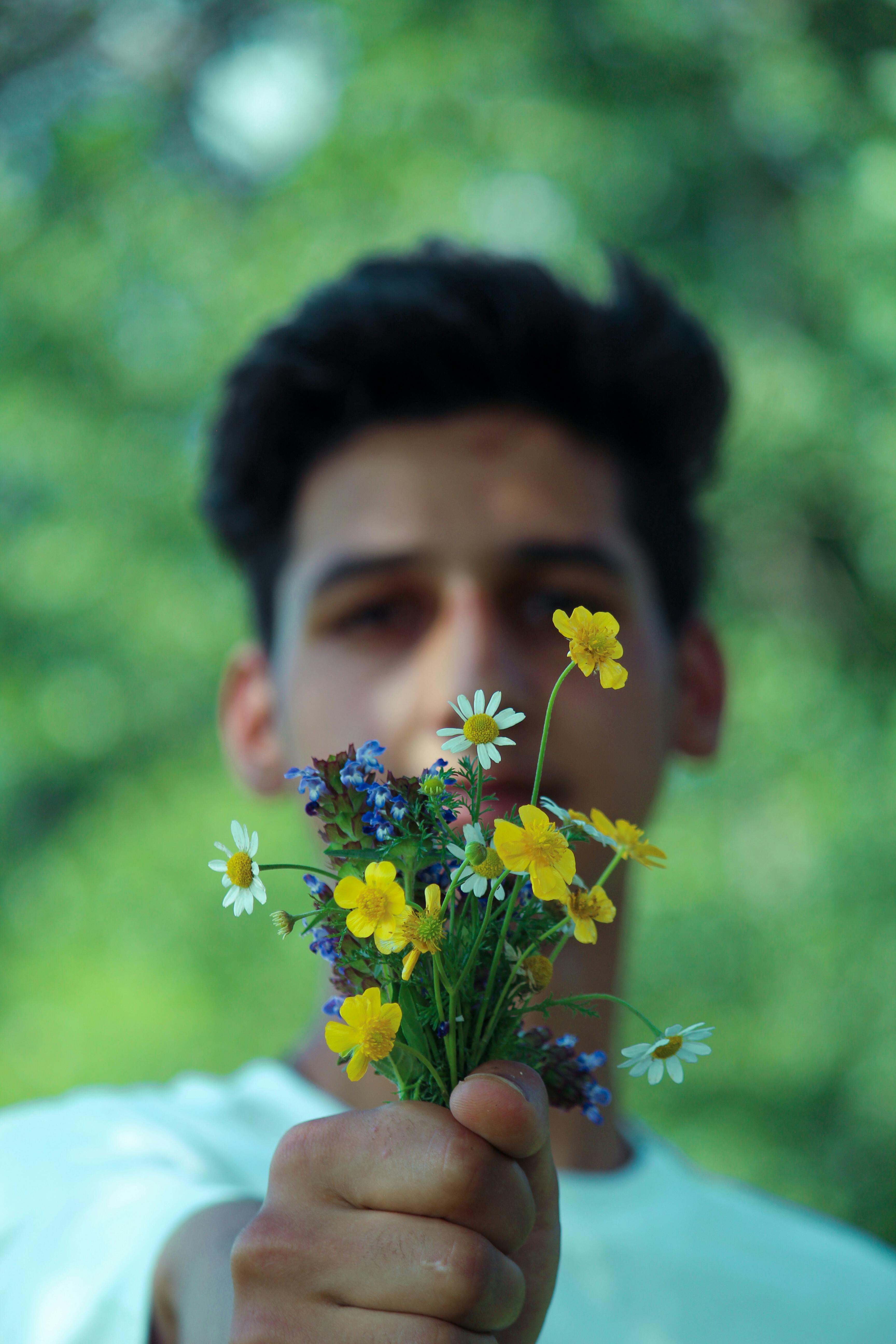 Un homme qui remet des fleurs | Source : Pexels