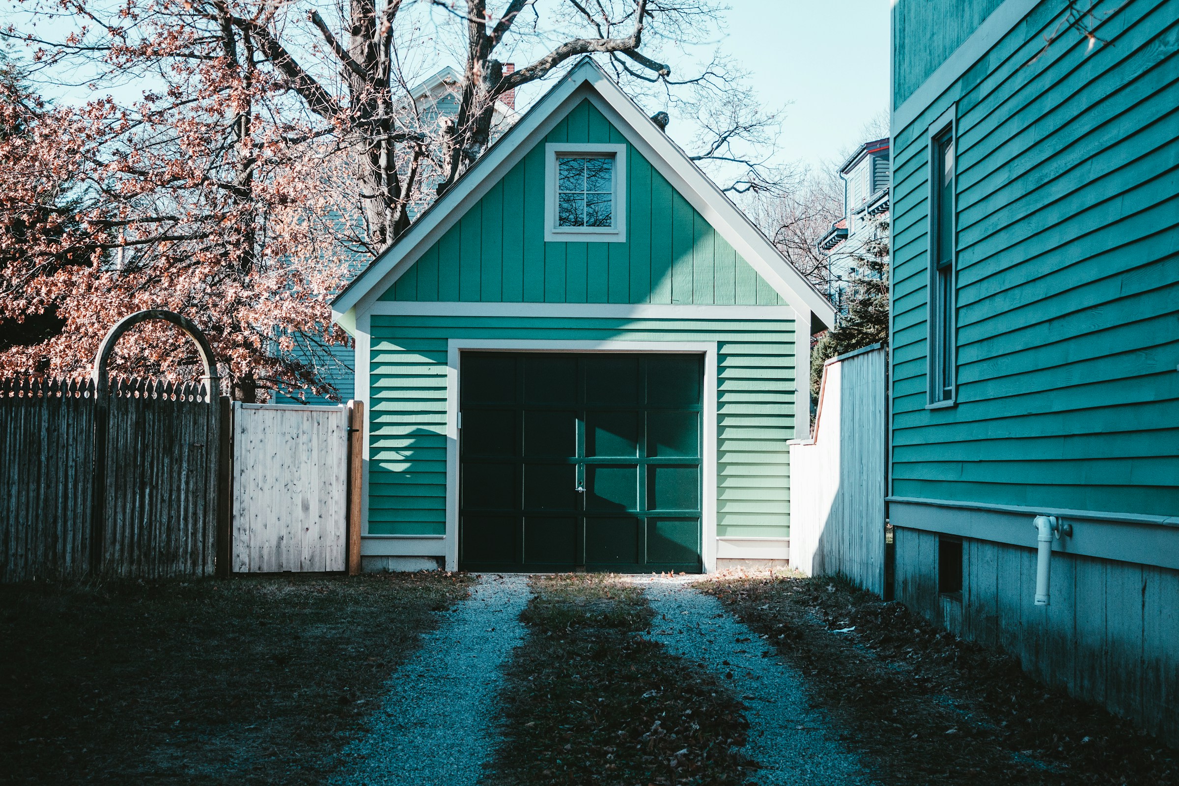 Un garage de couleur sarcelle dans une arrière-cour | Source : Unsplash