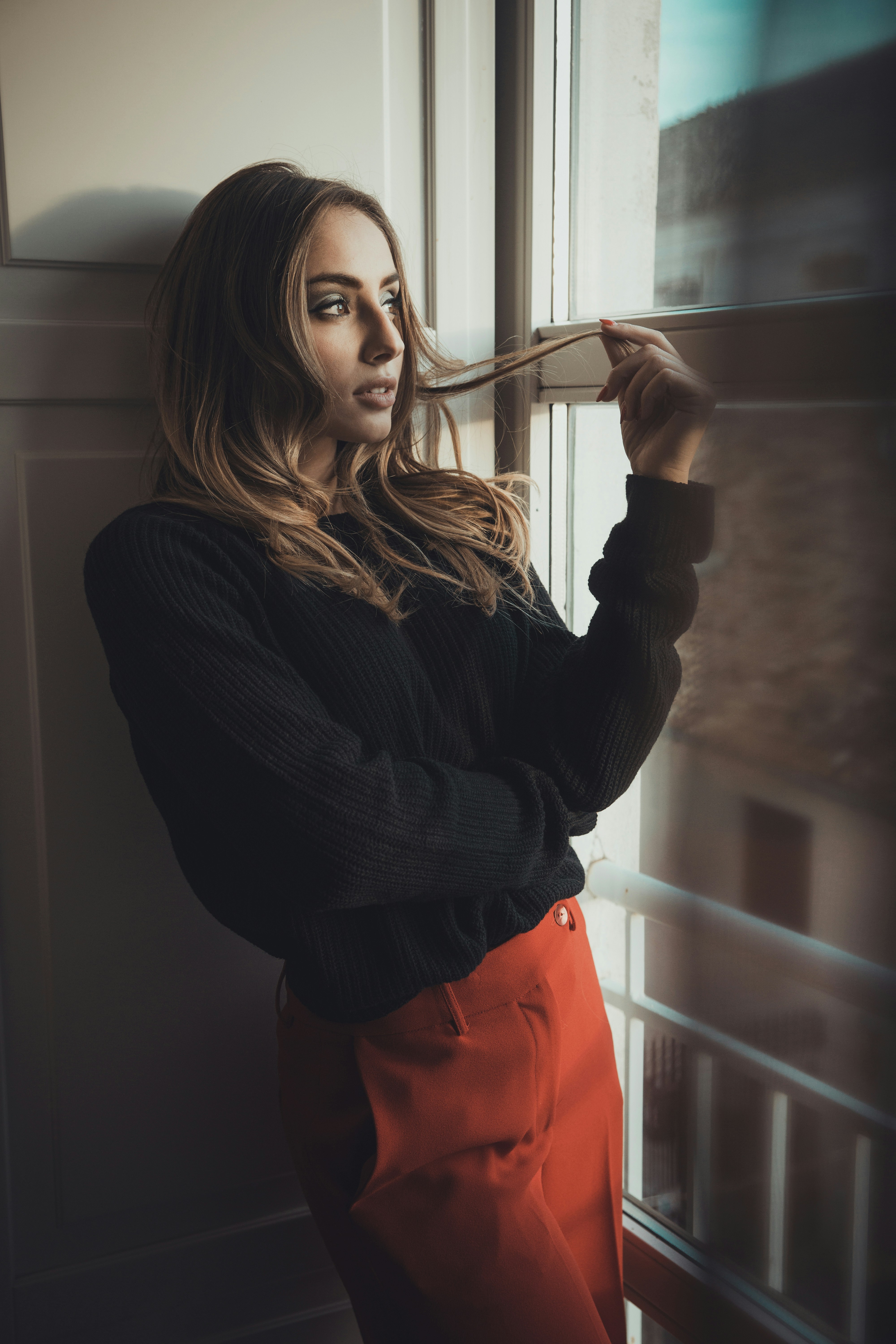 Une jeune femme debout près d'une fenêtre | Source : Unsplash