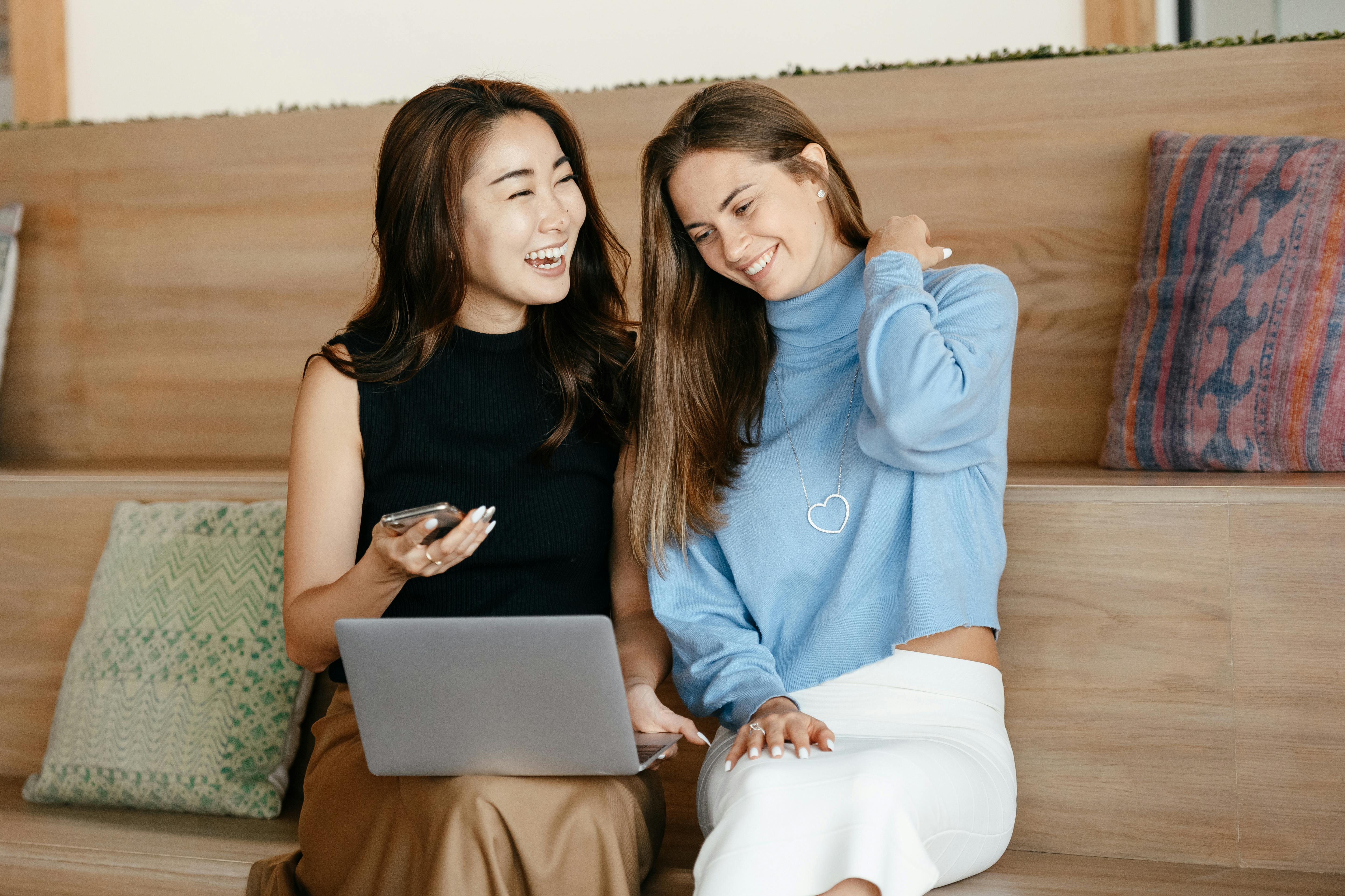 Deux femmes rient en regardant un ordinateur portable | Source : Pexels