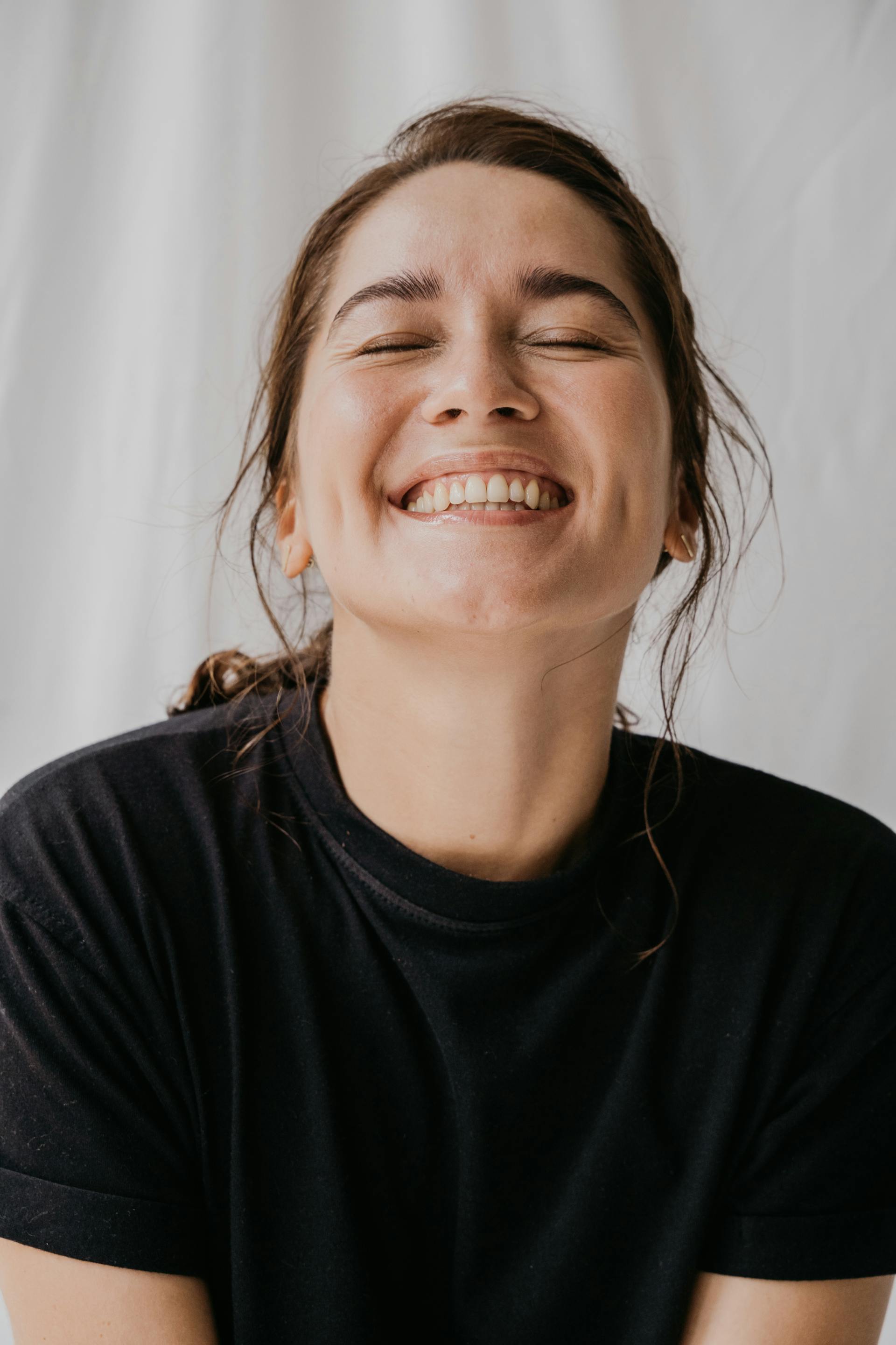 Une femme souriante, les yeux fermés | Source : Pexels