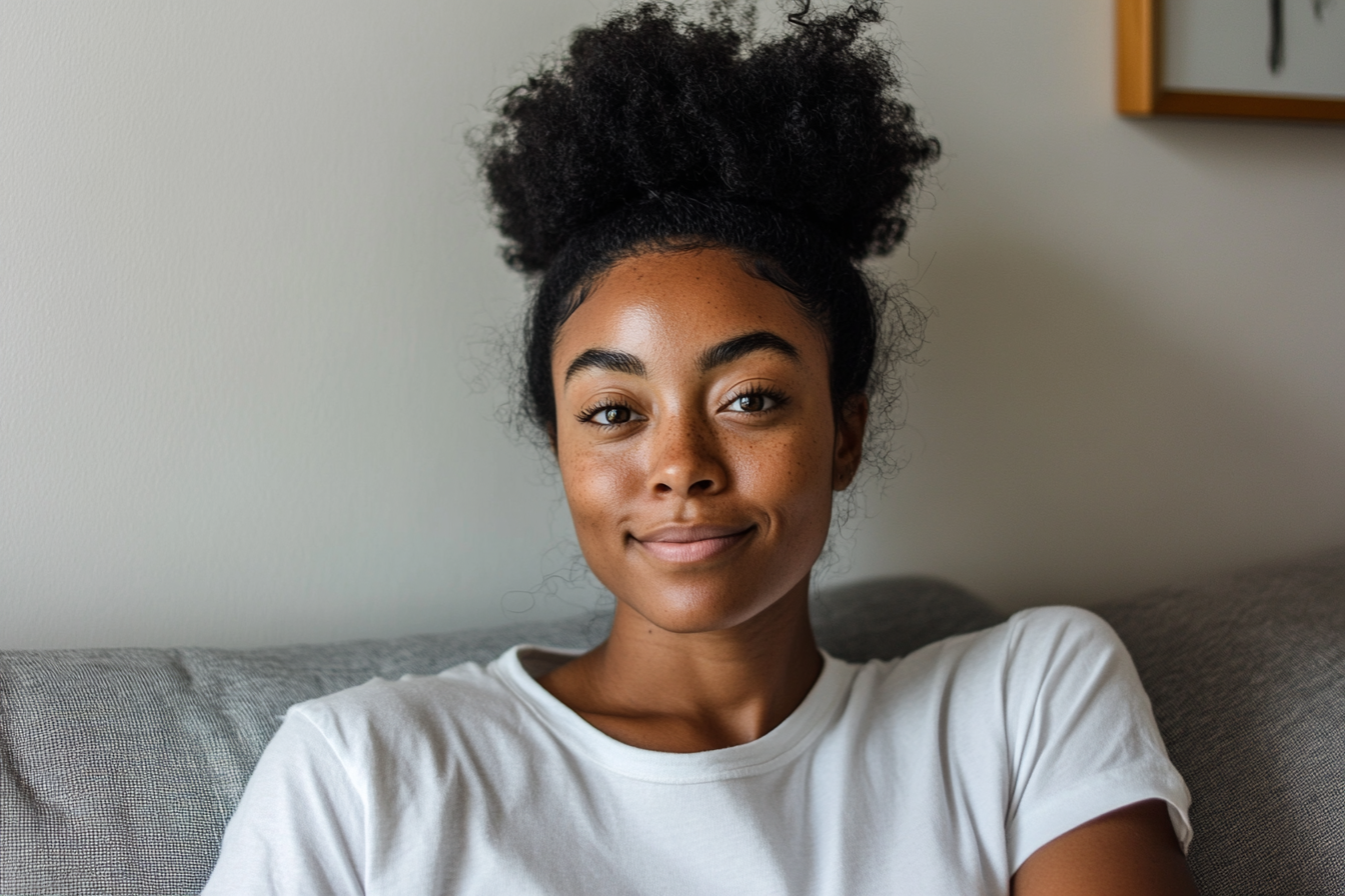 Une femme souriant assis sur un canapé dans un appartement | Source : Midjourney