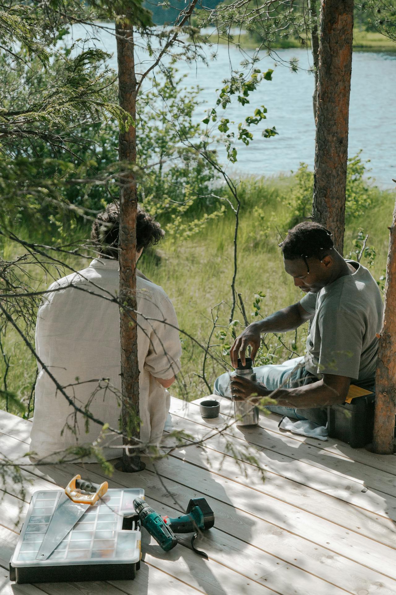 Deux hommes assis sur des planches en bois | Source : Pexels