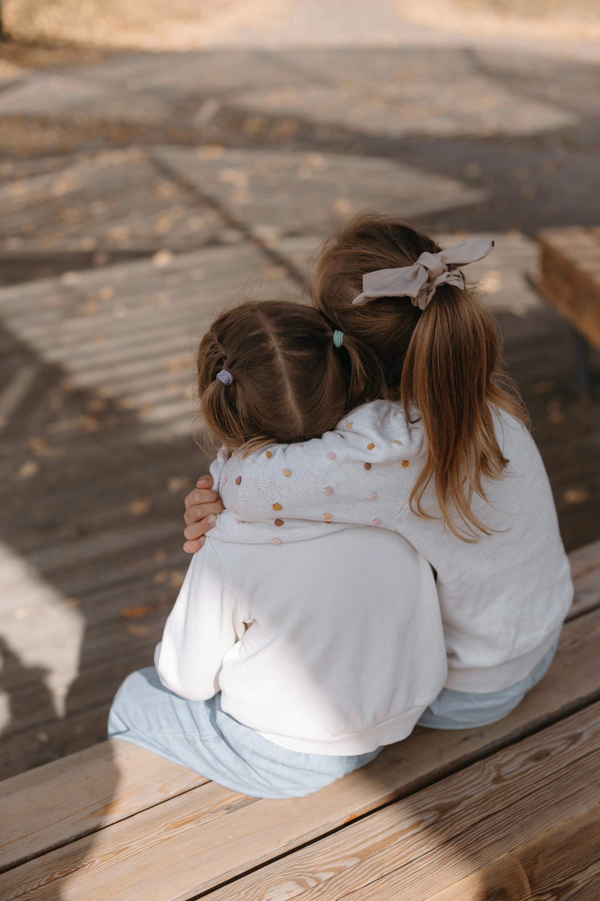 Deux filles assises et se serrant dans les bras | Source : Pexels
