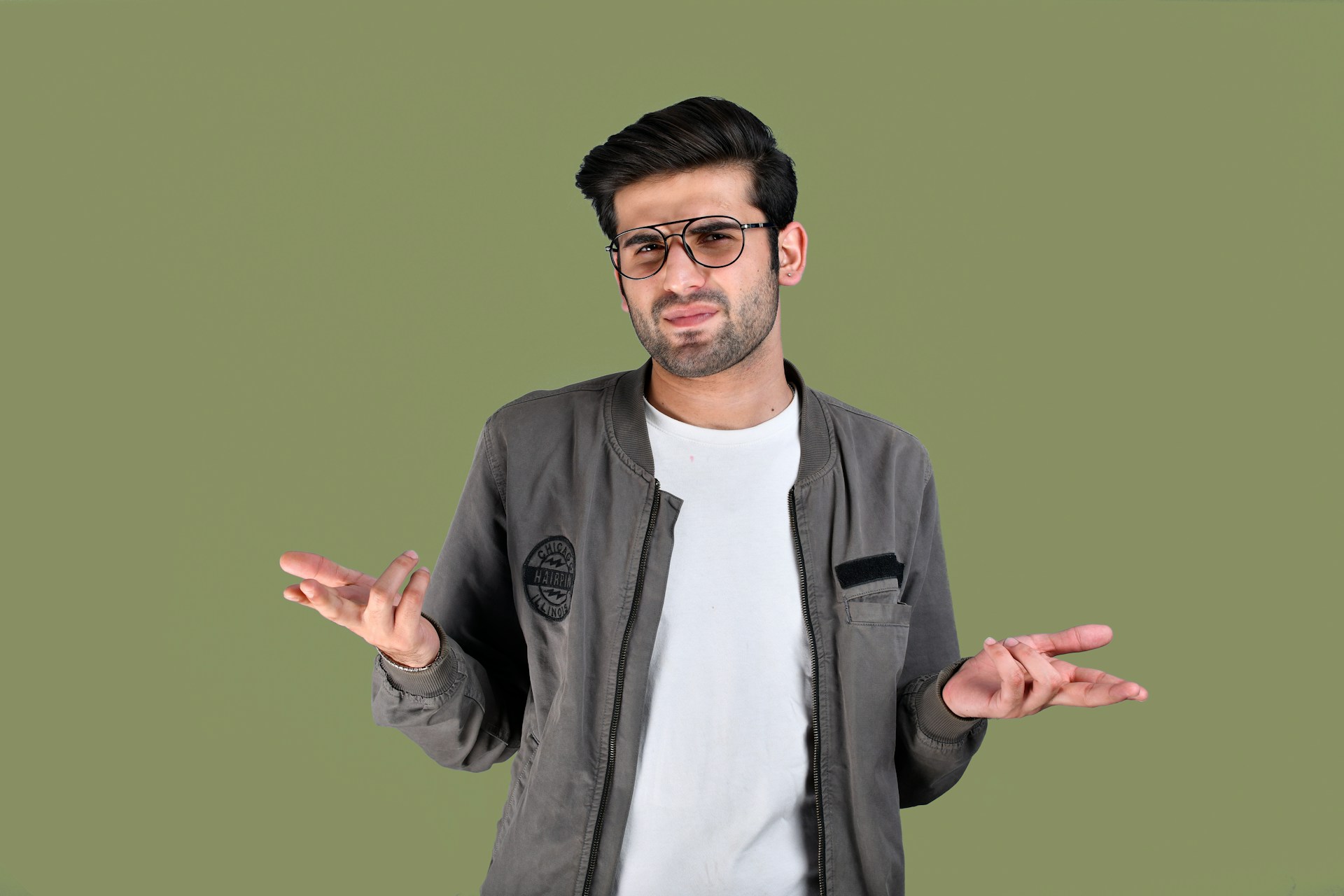 Un homme qui fronce les sourcils en haussant les épaules tout en parlant | Source : Unsplash