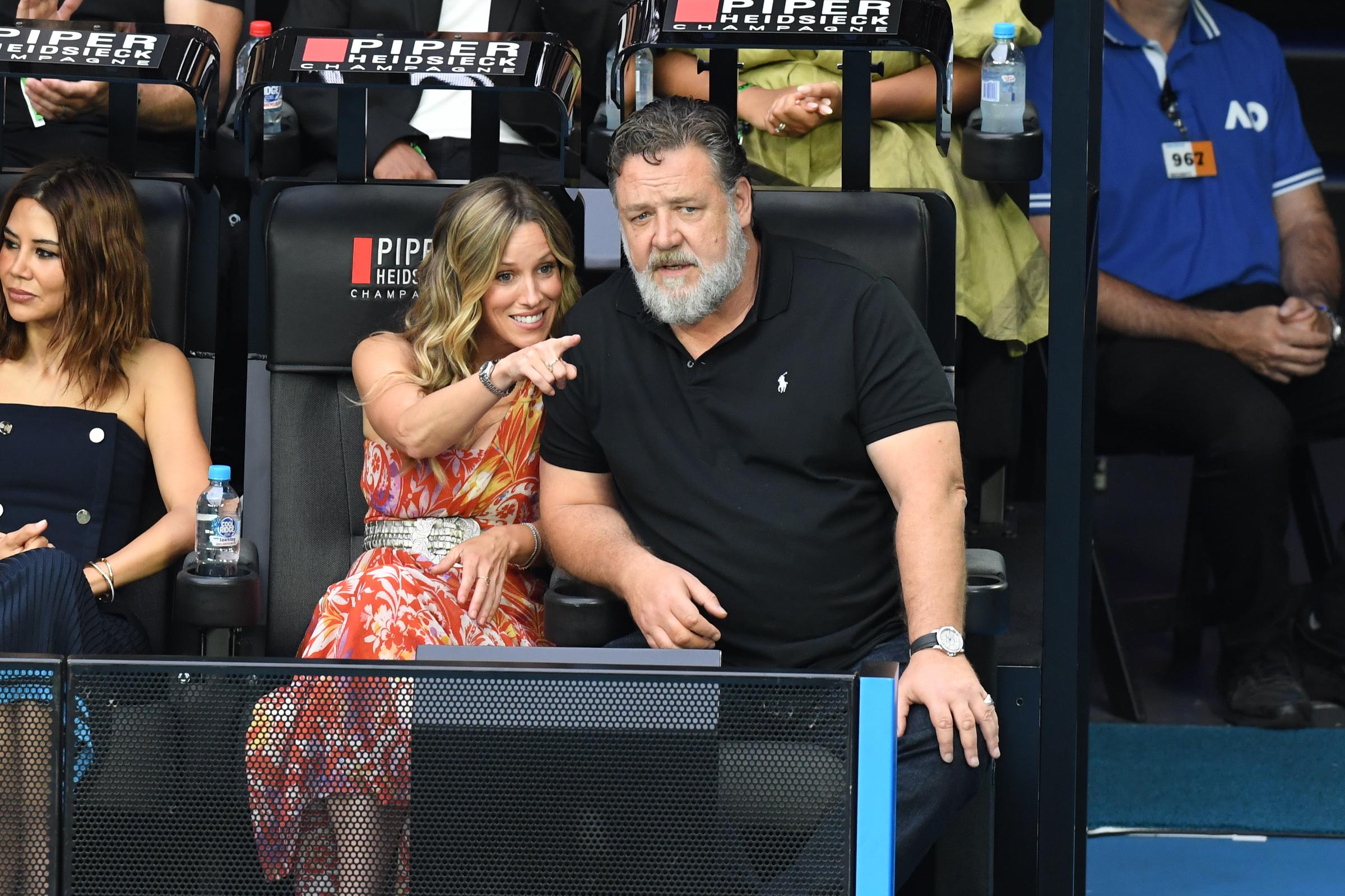 Russell Crowe assiste à la finale du simple dames de l'Open d'Australie 2023 le 28 janvier, assis au bord du court avec sa petite amie, Britney Theriot, à Melbourne. Vêtu d'un polo noir et d'un jean, il semble détendu et discret tandis qu'il regarde le match, affichant encore une silhouette plus corpulente avant de révéler sa perte de poids de 25 kg.