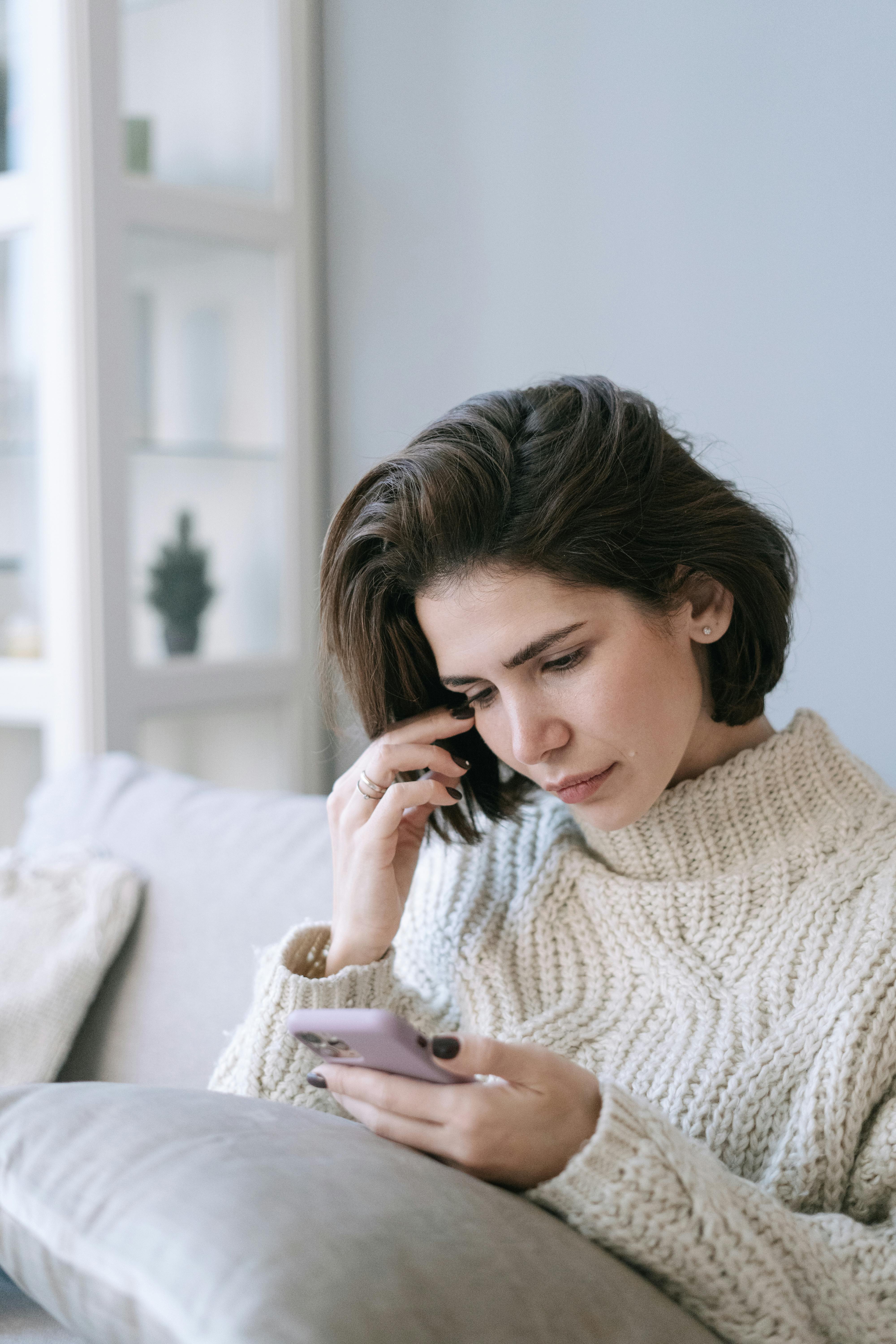 Une femme regardant son téléphone portable | Source : Pexels