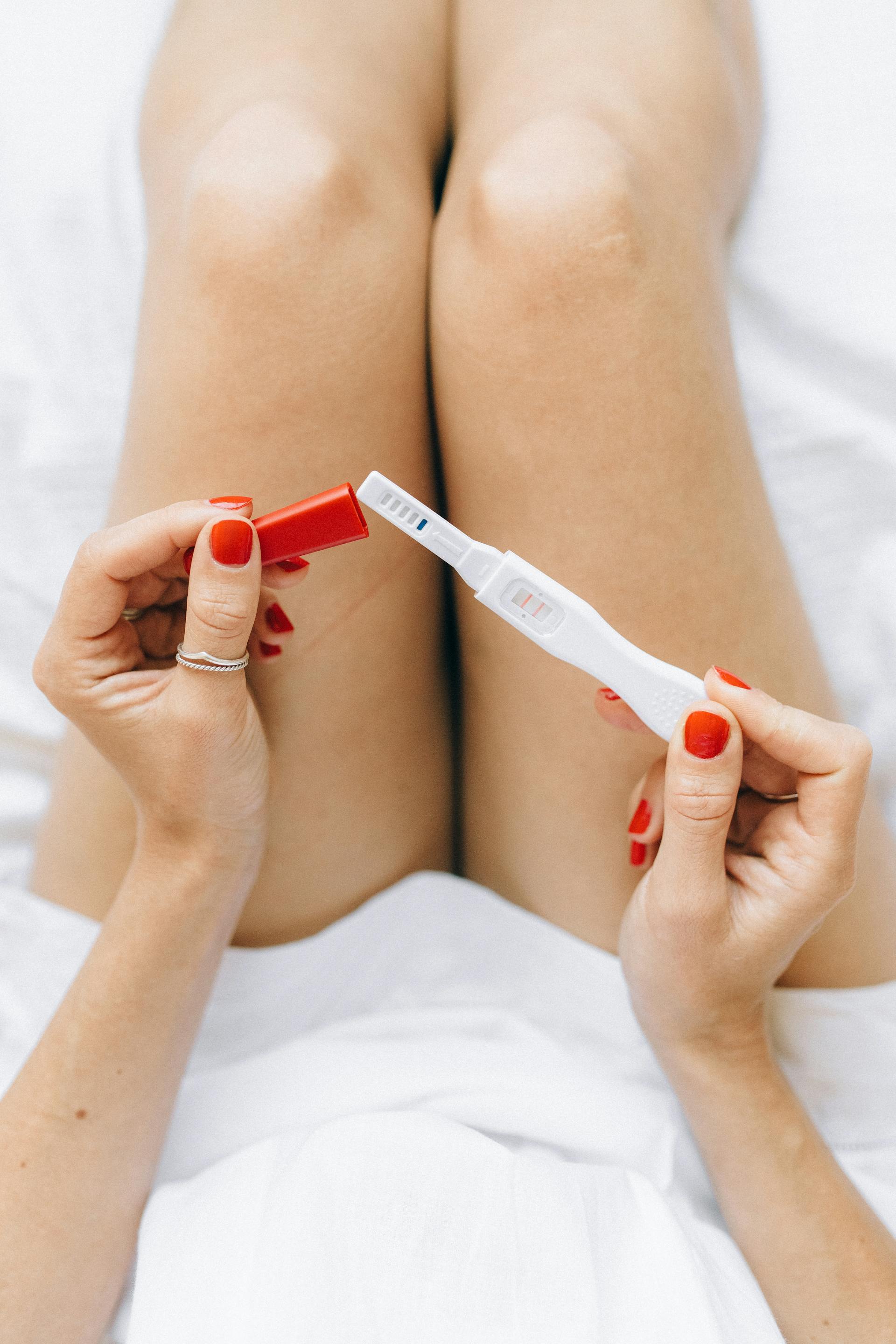 Une femme tenant un kit de test de grossesse | Source : Pexels