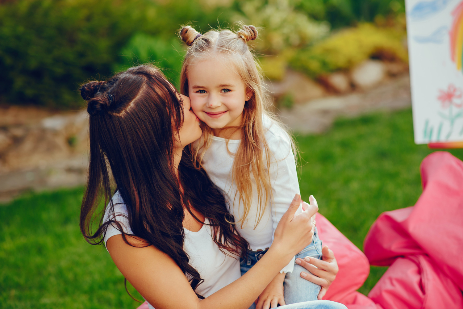 Une femme embrassant sa fille sur la joue | Source : Freepik